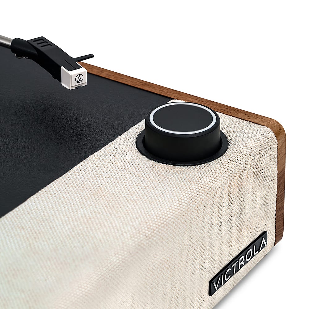 The image features a black and white case with a black knob on it. The knob is attached to a cord and is likely used for adjusting the volume or changing settings on a device. The case is made of wood and has a white and black color scheme. The knob is the main focus of the image, and it is positioned towards the center of the case.