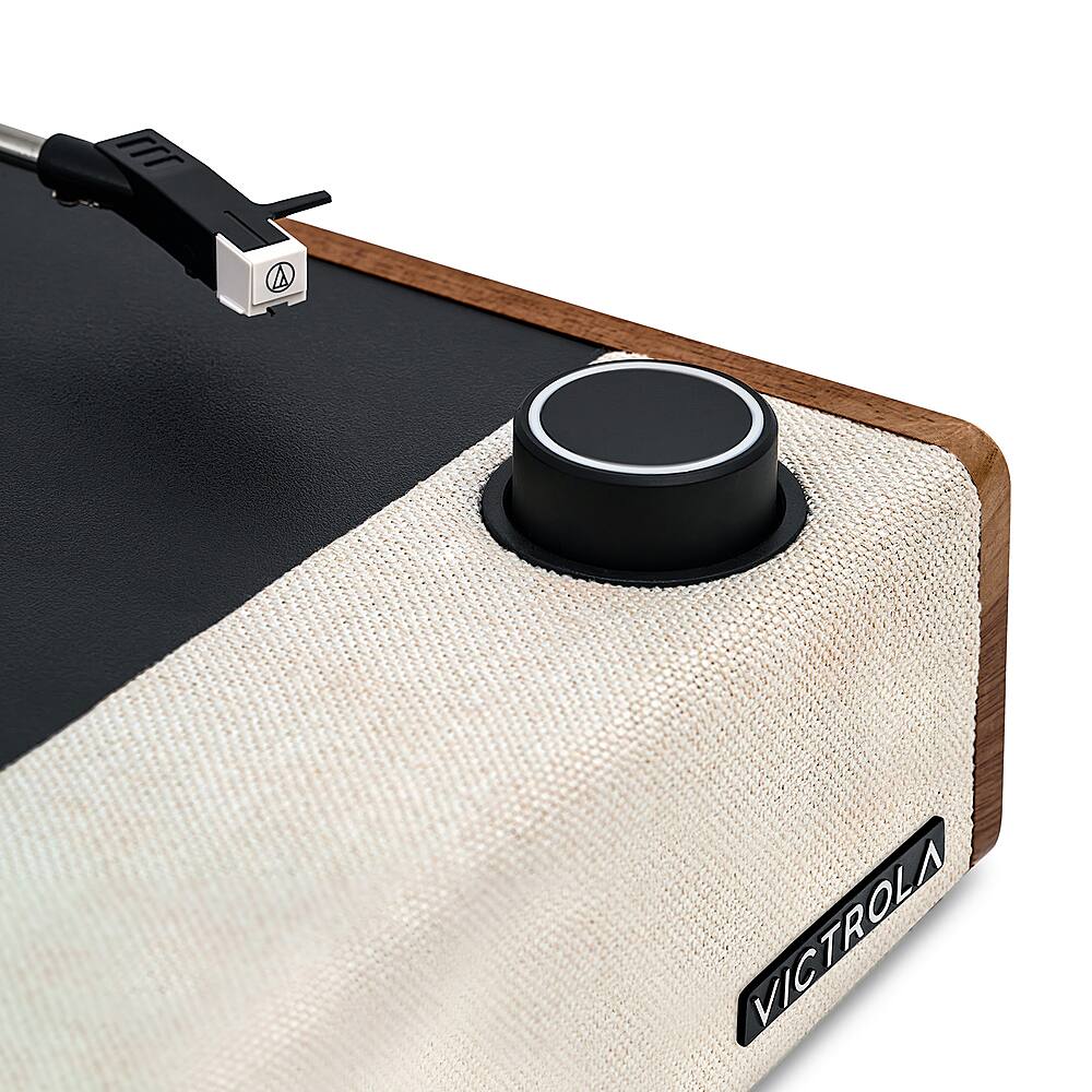 The image features a black and white case with a black knob on it. The knob is attached to a cord and is likely used for adjusting the volume or changing settings on a device. The case is made of wood and has a white and black color scheme. The knob is the main focus of the image, and it is positioned towards the center of the case.