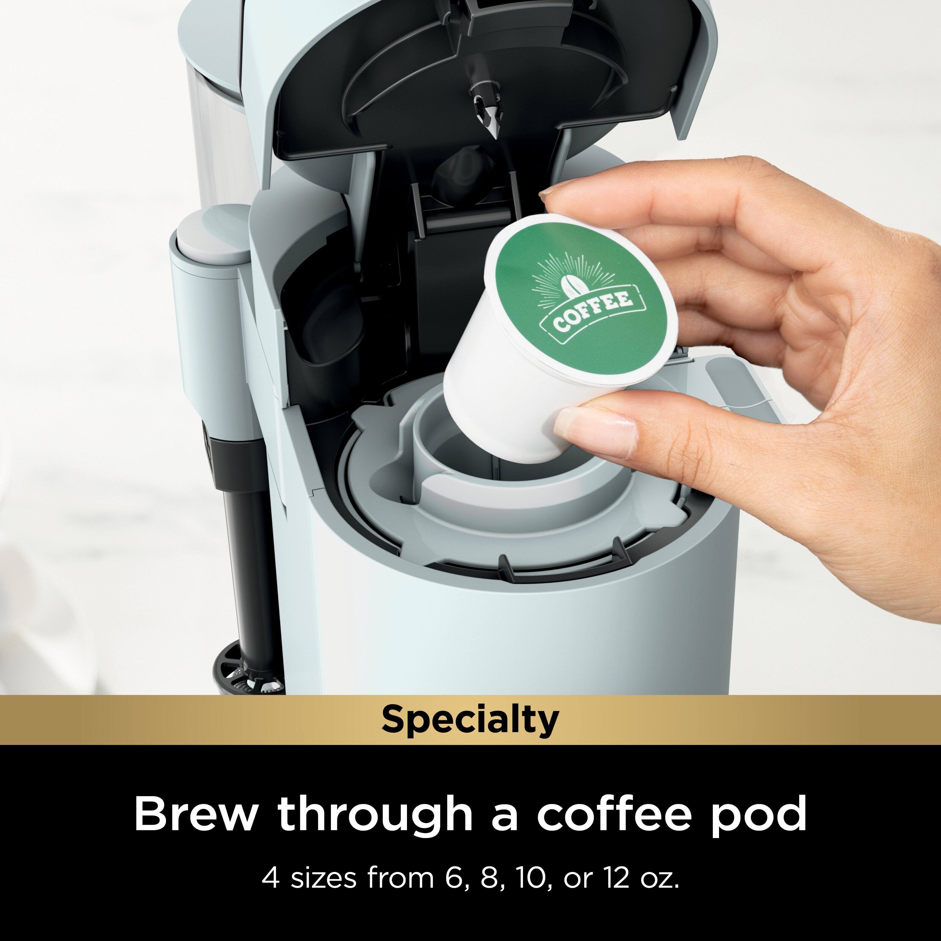 The image features a person's hand holding a coffee pod, which is placed inside a coffee maker. The coffee maker is designed to brew coffee through the coffee pod, offering four different sizes to choose from, ranging from 6 to 12 ounces. The coffee pod is specifically designed for specialty coffee, providing a convenient and efficient way to enjoy a delicious cup of coffee.