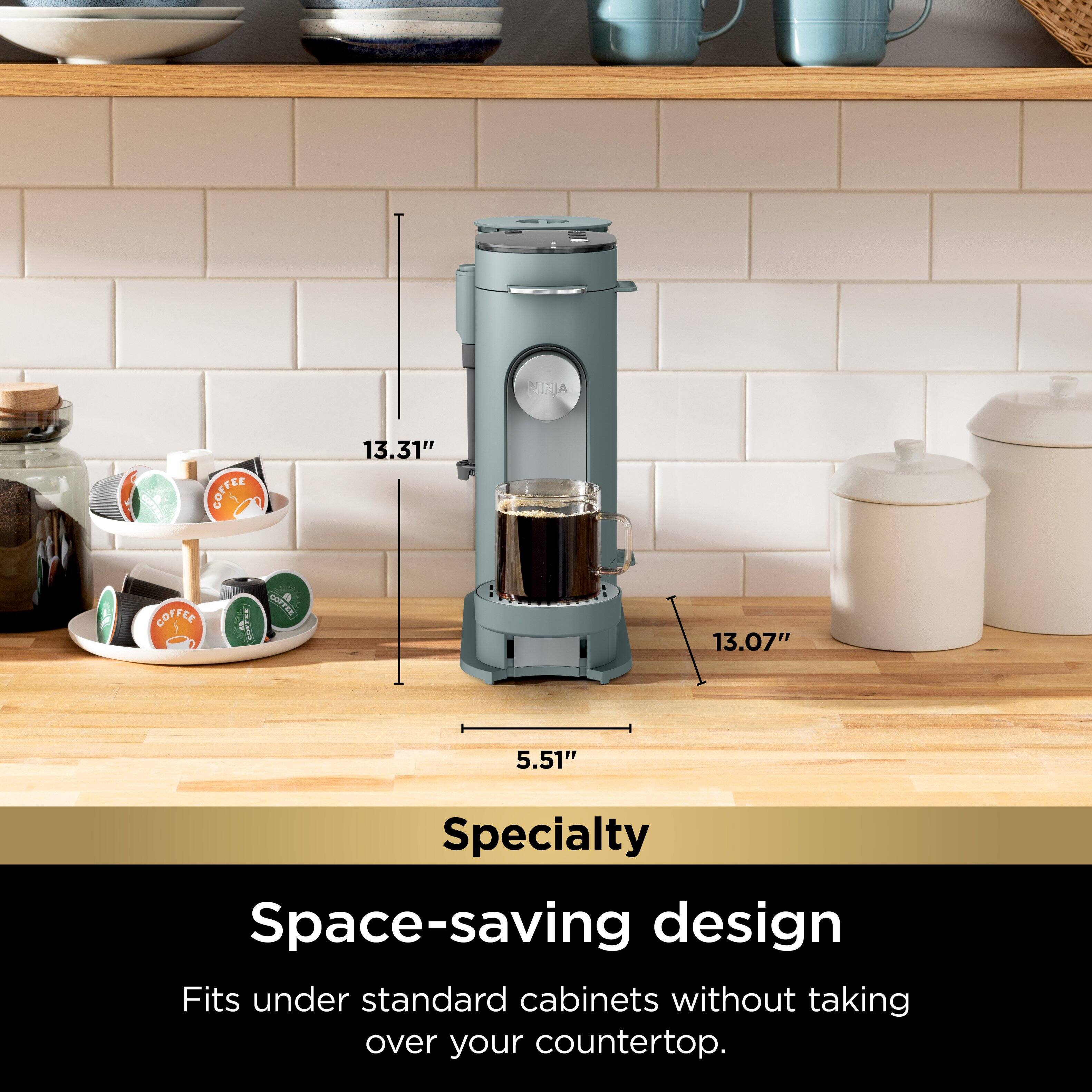 The image features a blue coffee maker, which is a specialty space-saving design that fits under standard cabinets without taking over your countertop. The coffee maker is placed on a wooden table, and it stands out as the main focus of the image. The table also has several cups and bowls arranged on it, adding to the overall aesthetic of the scene.