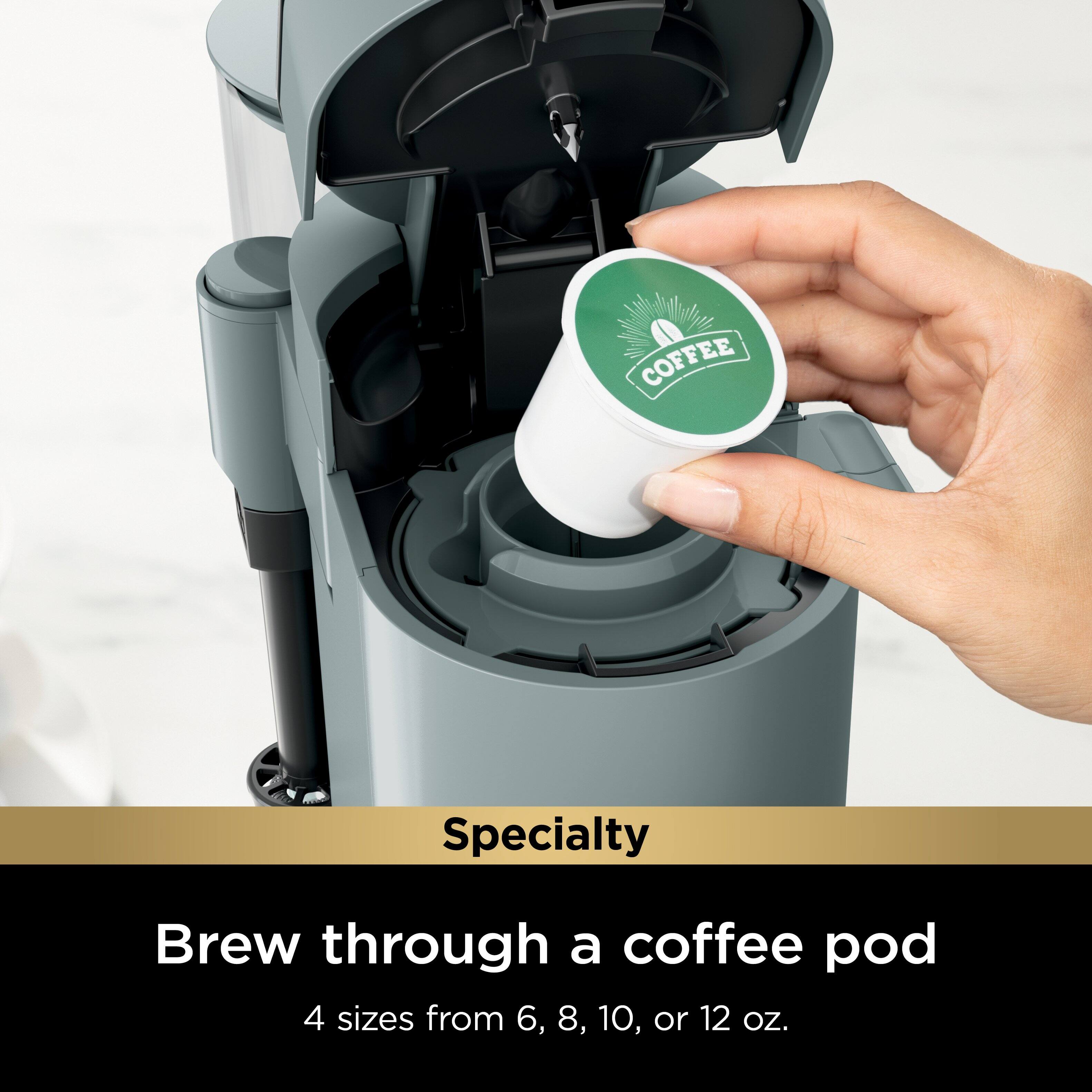 The image features a person holding a coffee pod in a coffee maker. The coffee maker is specifically designed for brewing coffee through a coffee pod, offering four different sizes to choose from, ranging from 6 to 12 ounces. The coffee pod is placed in the coffee maker, and the person is either preparing to brew a cup of coffee or has just finished brewing it. The image showcases the convenience and efficiency of using a coffee pod system for making coffee.