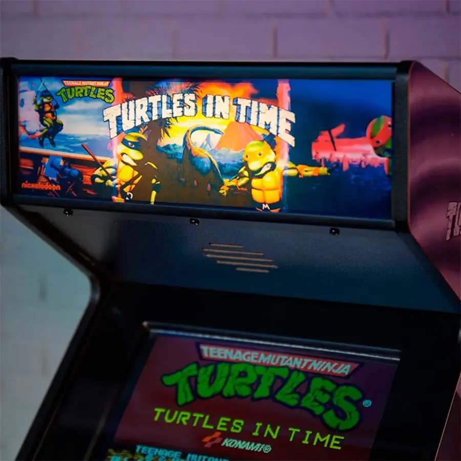 The image features a video game machine with a Teenage Mutant Ninja Turtles game displayed on the screen. The game is called "Teenage Mutant Ninja Turtles: Turtles in Time." The machine is likely an arcade-style game, and the game is set in a dark environment.