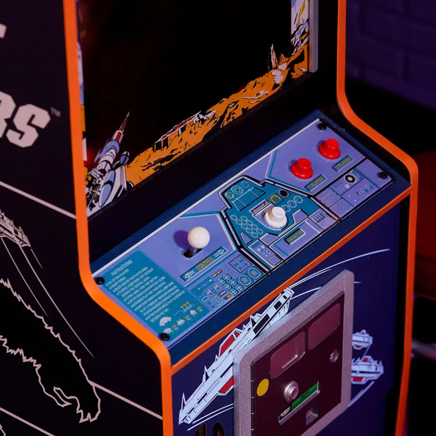 The image features a video game machine with a large screen and a control panel. The machine is designed for playing video games, and it has a unique design that sets it apart from other gaming consoles. The machine is likely part of an arcade or gaming center, where players can enjoy a variety of games. The control panel is located on the front of the machine, allowing players to interact with the game using buttons and other controls. The machine is also equipped with an instruction manual, which can be used to learn how to play the games and understand the controls.
