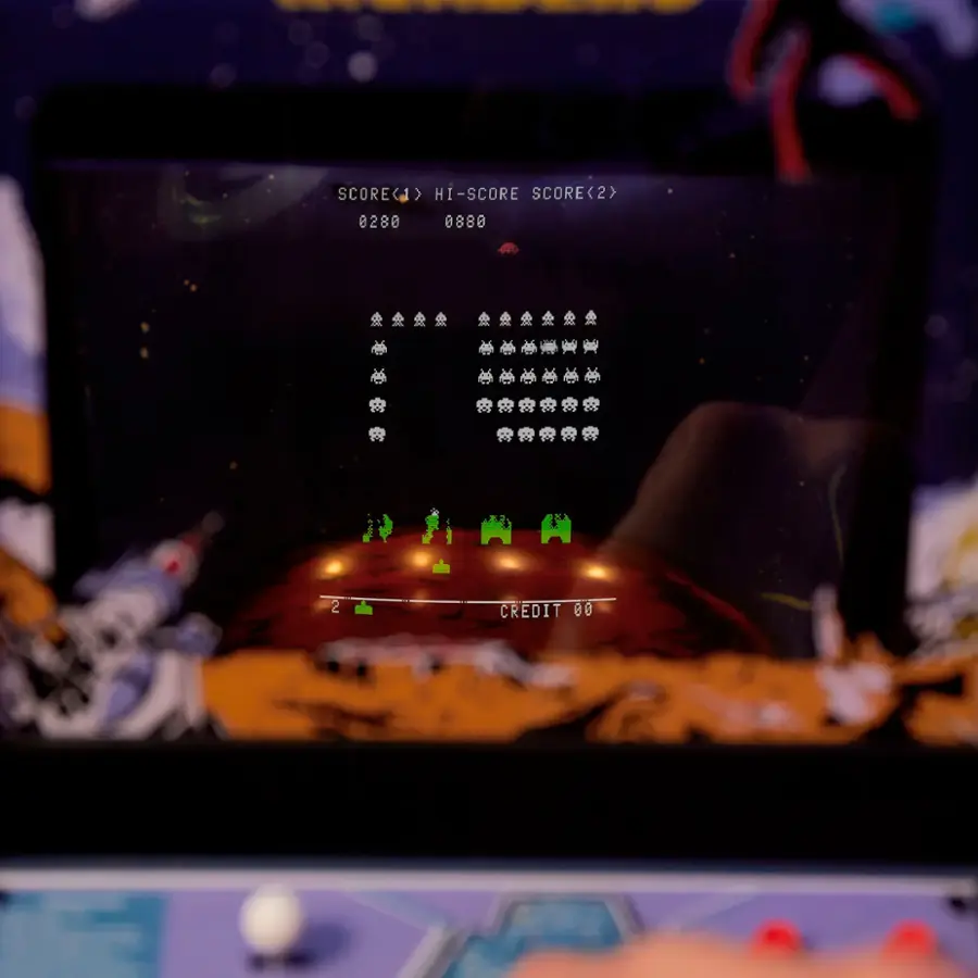 The image shows a video game screen with a score of 280 displayed. The game is set in a space environment with a spaceship and aliens. The player is using a joystick to control the game, and the screen is filled with aliens and spaceships. The game is likely a classic arcade game, as evidenced by the presence of a joystick and the space-themed setting.