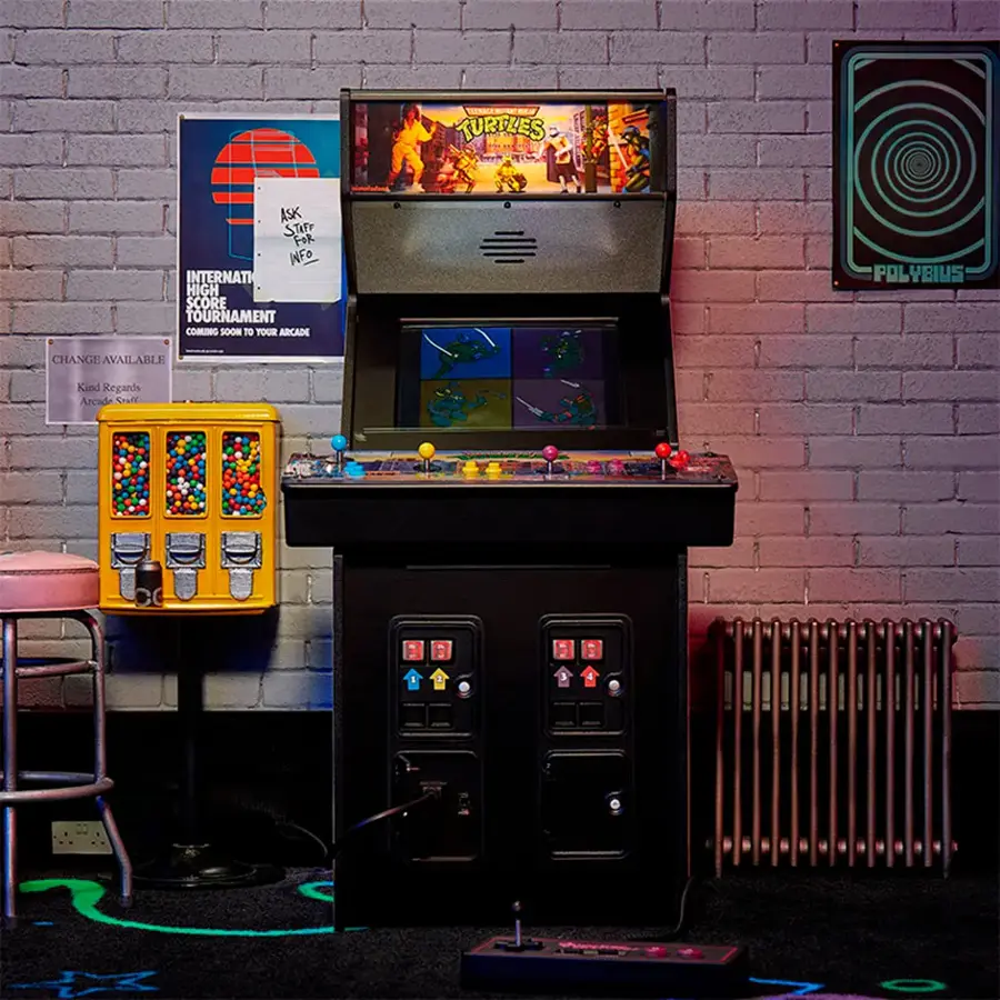 The image features a black arcade machine with a Turtles game on display. The machine is located next to a yellow machine and a brick wall. The arcade machine is set up for a high score tournament, which is coming soon. The machine is also equipped with a Polybius change available.