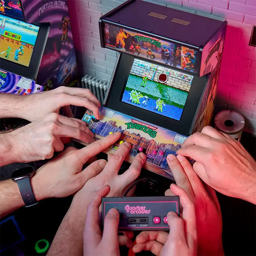 The image shows a group of people playing a video game together, specifically Teenage Mutant Ninja Turtles. They are using remote controllers to interact with the game, which is displayed on a TV. The group consists of five people, with one person on the left side, two people in the middle, and two more people on the right side. The TV is positioned in the center of the scene, and the remote controllers are being held by the players. The atmosphere appears to be fun and engaging, as the group enjoys their time playing the game.