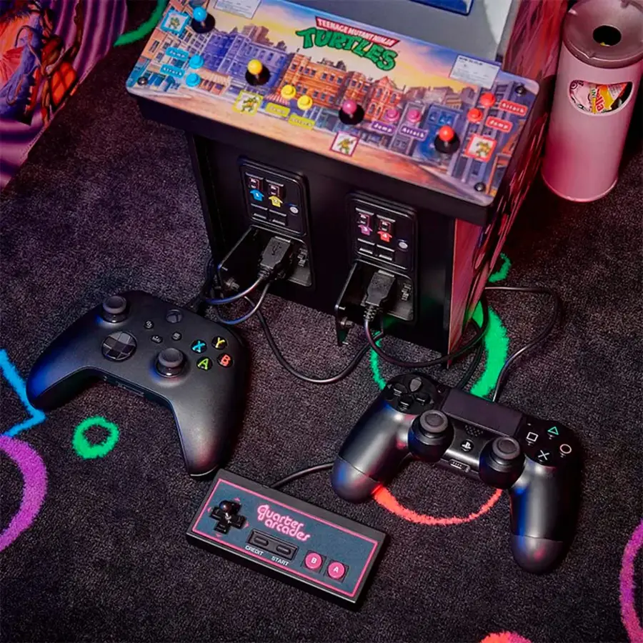 The image features a Teenage Mutant Ninja Turtles arcade machine with two game controllers sitting on a carpeted floor. The machine is designed for two players, and the controllers are placed in front of the machine, ready for use. The arcade machine is likely set up for a fun gaming session, and the controllers are connected to the machine, allowing players to enjoy the game.