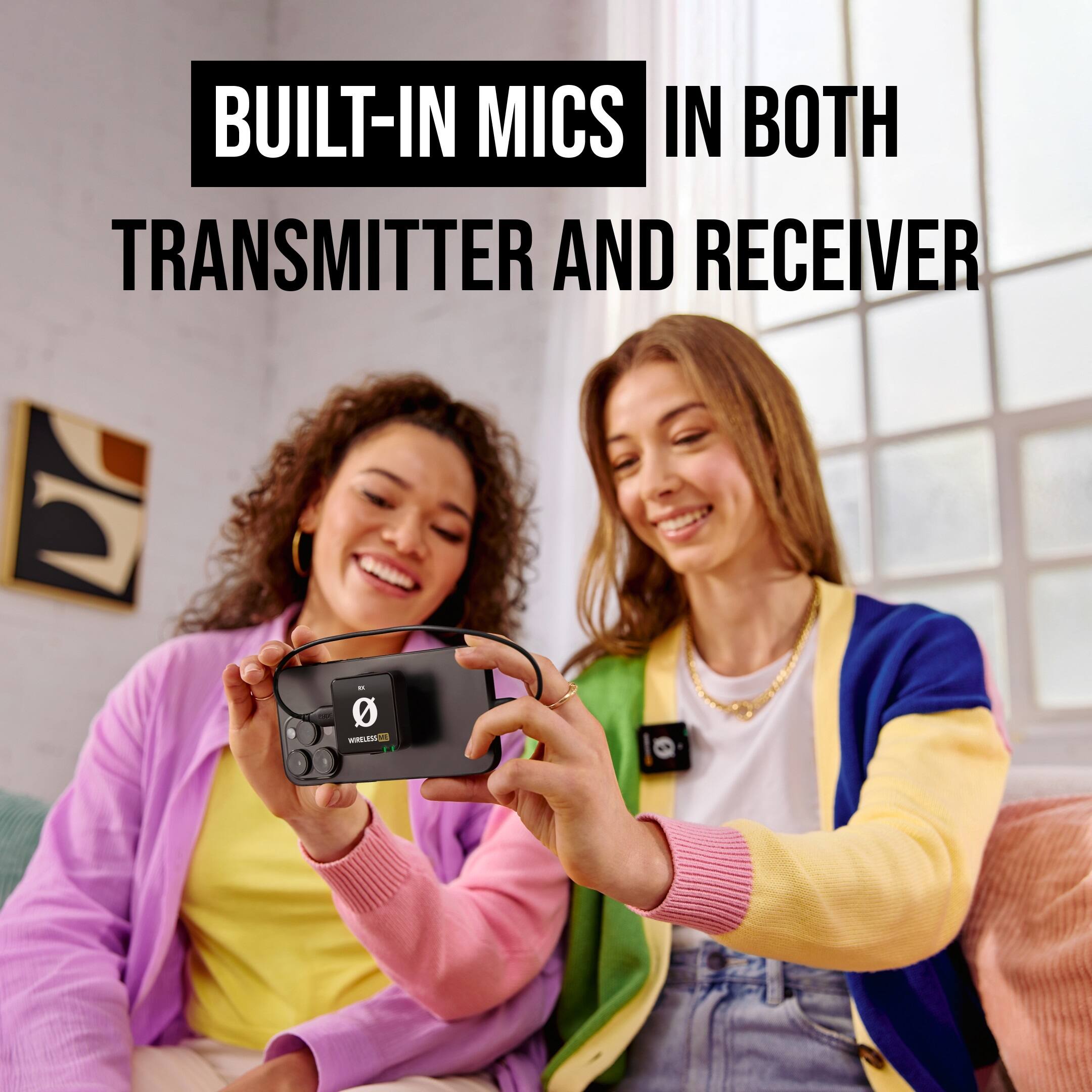 The image shows two women sitting next to each other, both holding up a small device with built-in mics. They are likely demonstrating the device's features, such as its built-in mics, which allow for clear communication and recording. The women are smiling and seem to be enjoying their time together while showcasing the device.