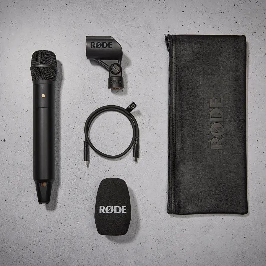 The image features a black microphone, possibly a Rode Rec, standing upright against a white background. The microphone is positioned in the center of the image, and its height is approximately 1.5 times its width.