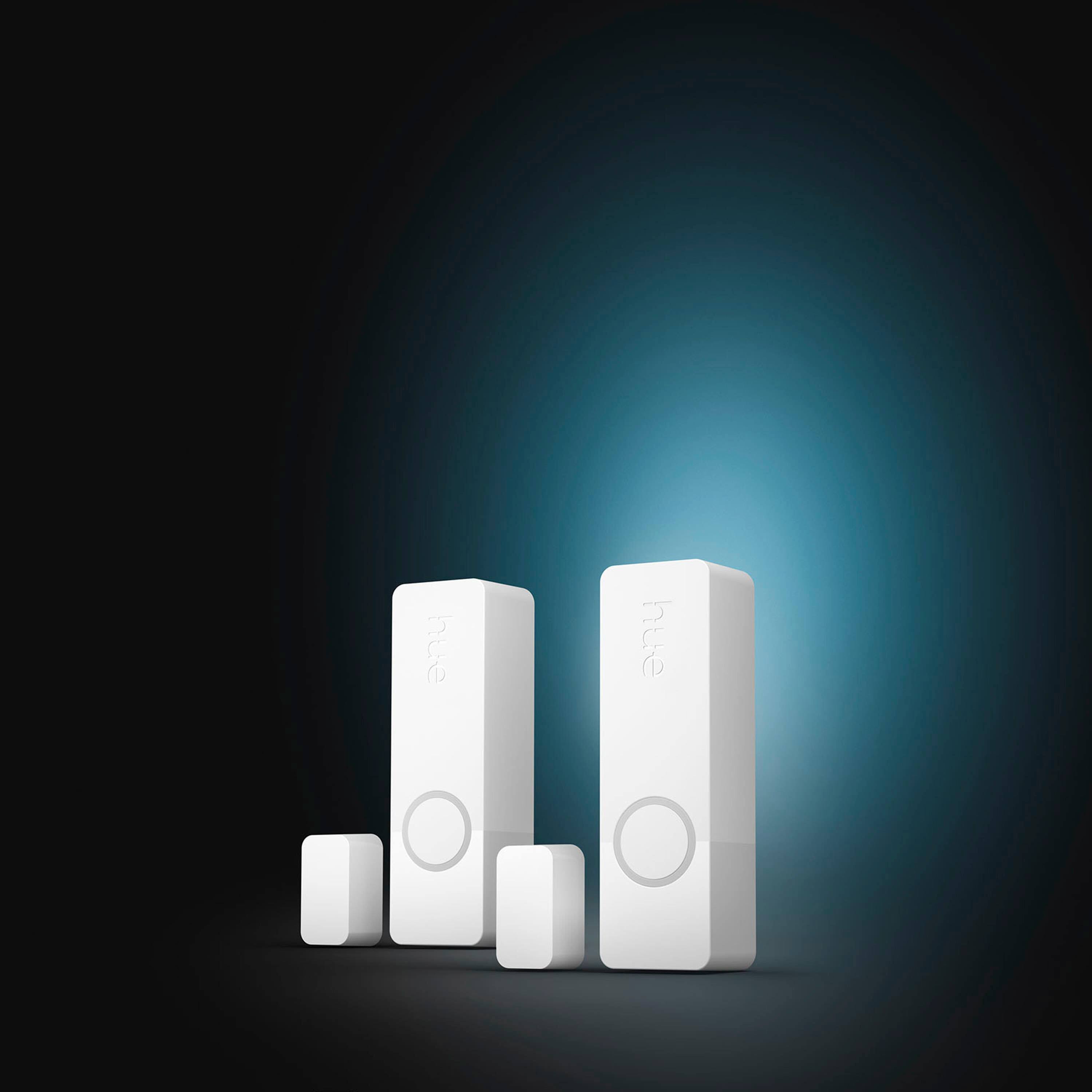 The image features three white electronic devices, possibly remotes, standing next to each other in a dark background. The largest text displayed in the image is "hue," which is likely the brand or model of the devices. The other text, "hue hue," is a repetition of the same word, which may be an artistic choice or a play on words.