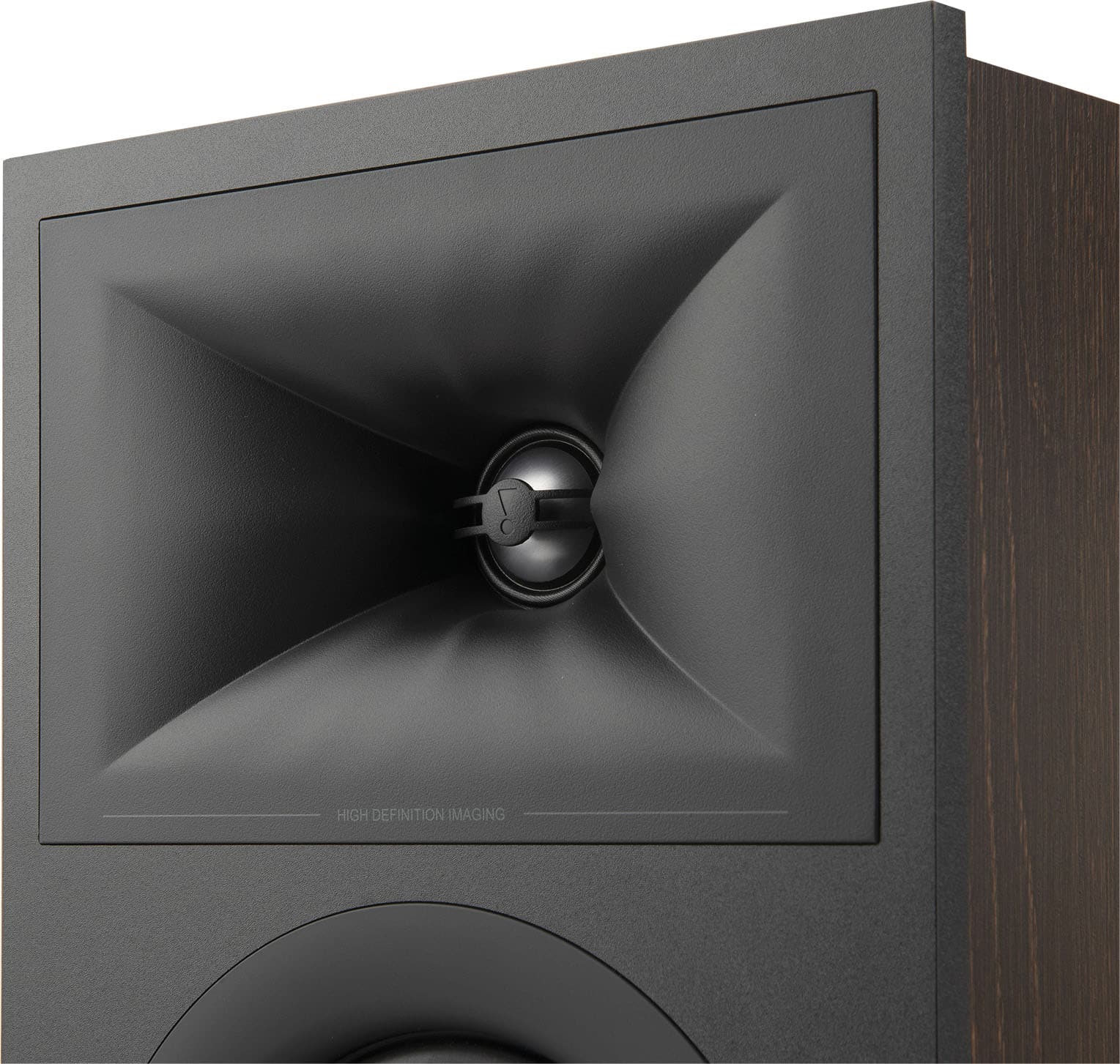 The image features a large speaker that is designed for high-definition imaging. The speaker is black and has a large, curved shape, which is likely intended to provide better sound quality and a more immersive listening experience. The speaker is placed on a wooden table, which adds to the overall aesthetic of the setup.