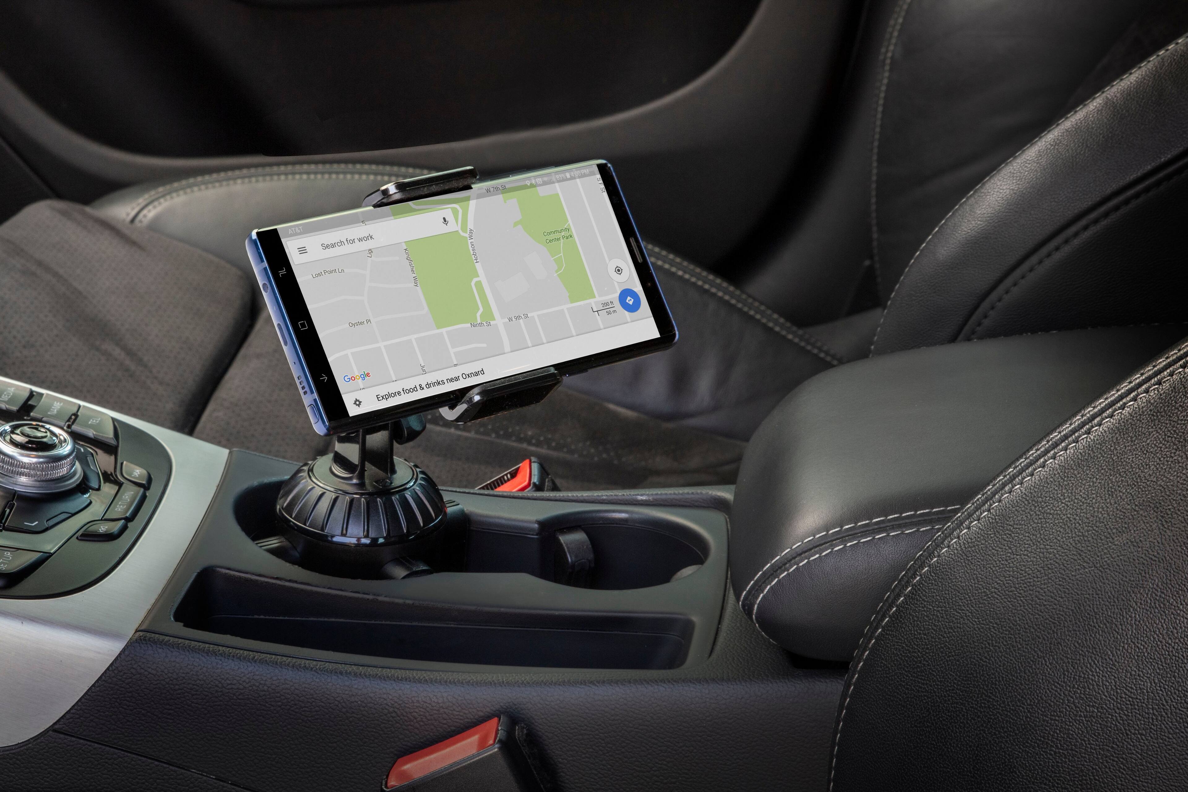The image shows a car with a GPS device mounted on the dashboard, displaying a map of Los Angeles. The GPS is connected to the car's stereo system, providing directions and information to the driver. The car's interior is black, and the GPS is placed on a stand, making it easily visible and accessible for the driver.