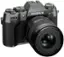 The image features a Fujifilm X-T50 camera with a large lens. The camera is black and has a Fujinon lens attached to it. The lens is described as an aspherical lens, which is designed to provide better image quality and reduce distortion. The camera is positioned on a white background, making it the main focus of the image.