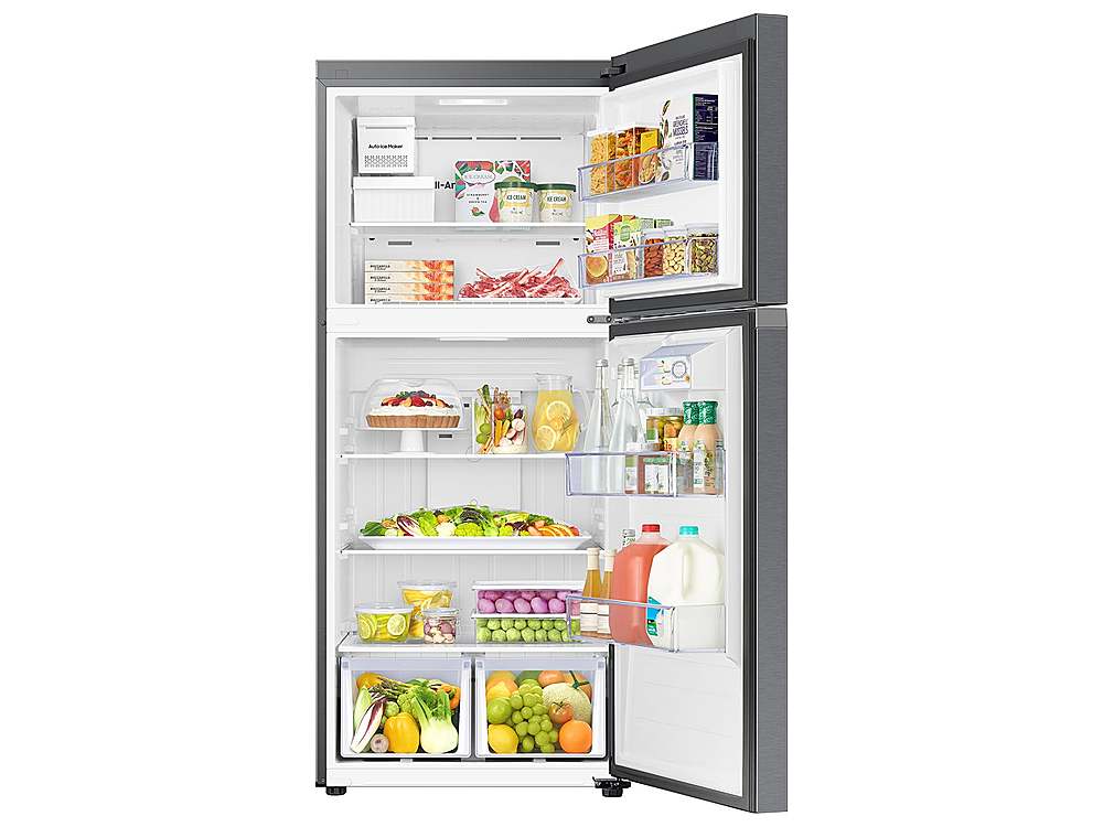 The image shows a refrigerator with its door open, revealing a variety of food items. There are several bottles of milk, juice, and other beverages, as well as a variety of fruits such as apples, oranges, and bananas. The refrigerator is well-stocked, providing a diverse selection of food and drinks for consumption.