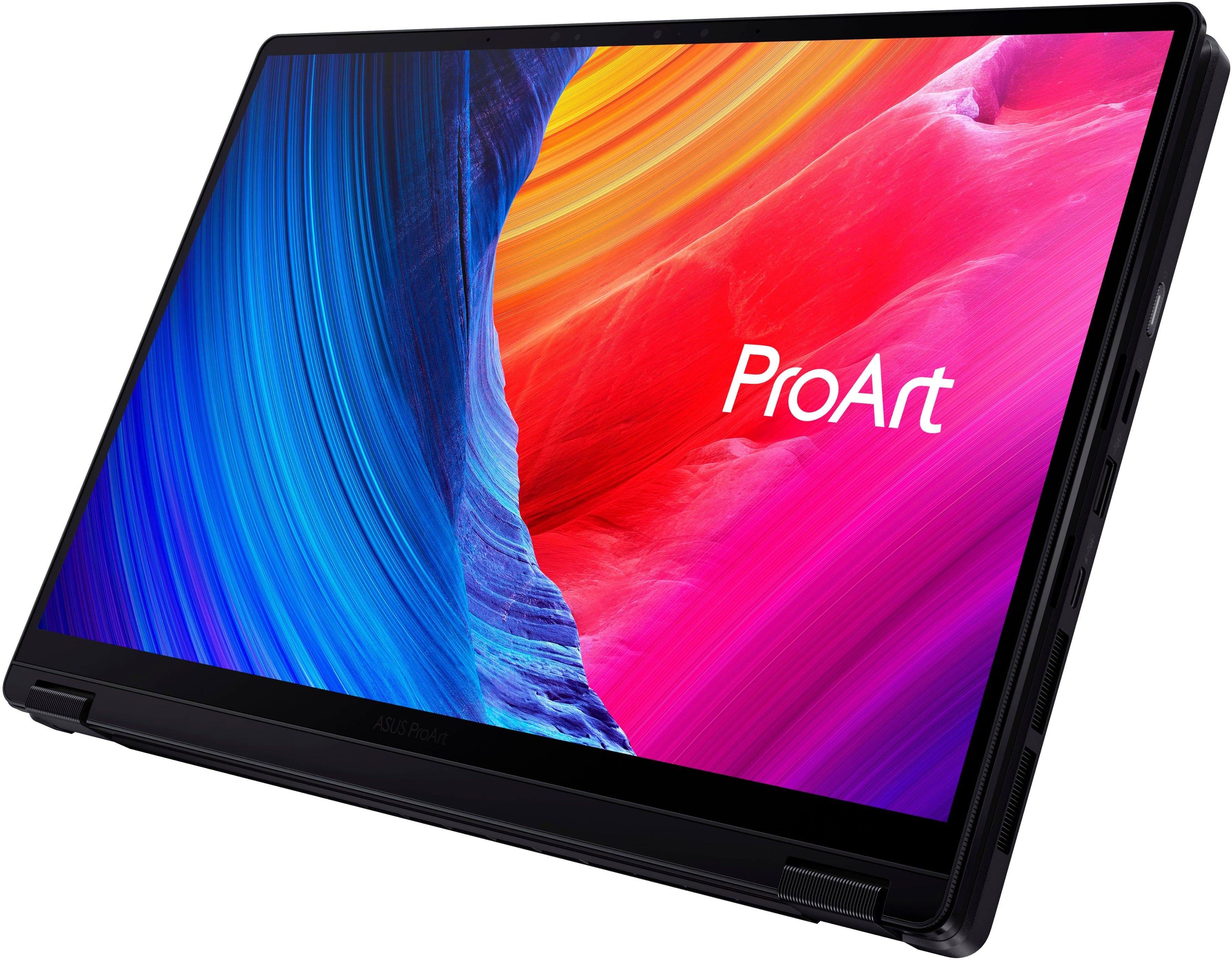 The image features a laptop computer with a vibrant, colorful background. The laptop screen displays the word "ProArt" in large text, indicating that it is an ASUS ProArt laptop. The laptop is positioned in a way that showcases its screen, making it the main focus of the image.