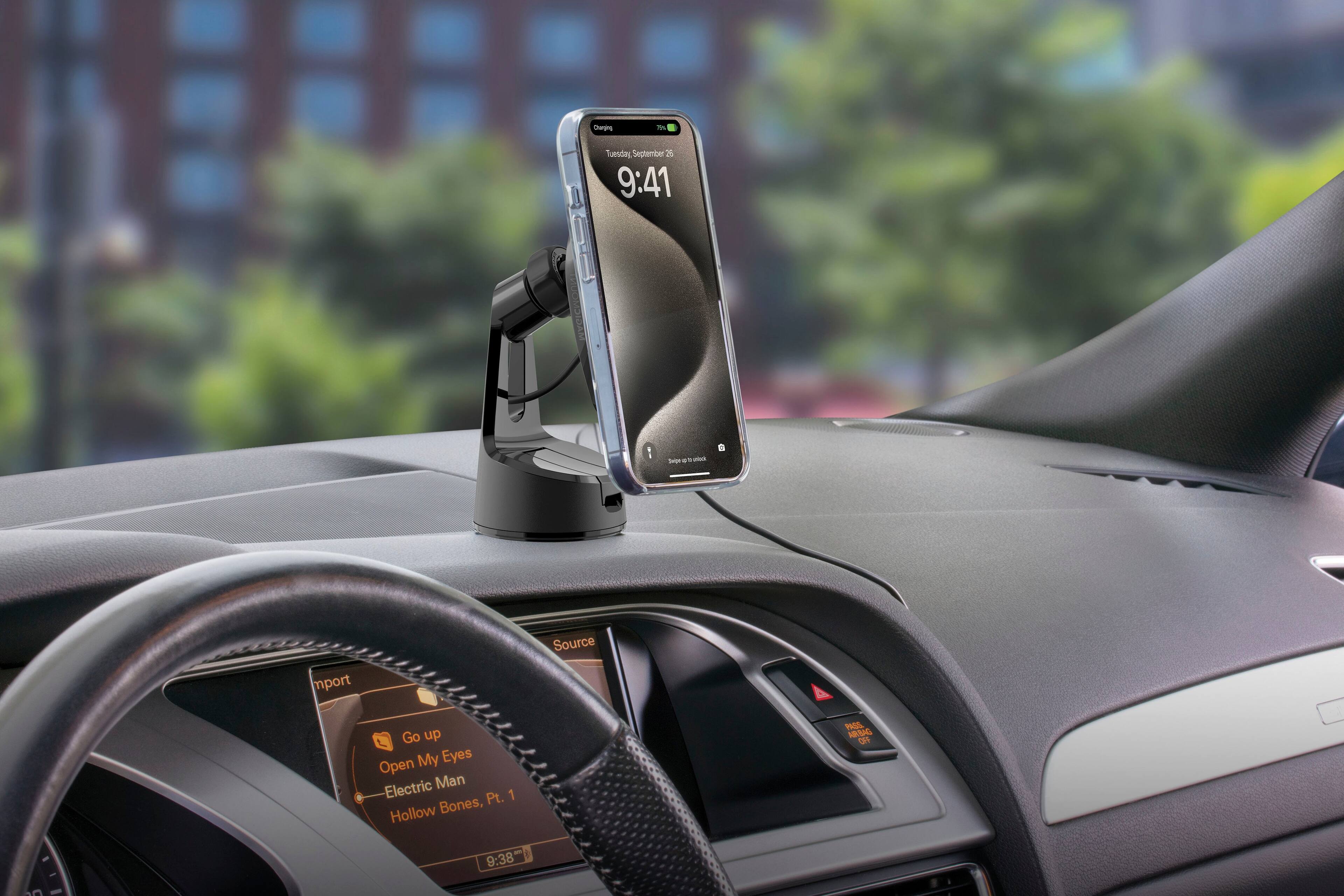 The image shows a cell phone placed on a car's dashboard, with the time displayed as 9:41. The car is parked in front of a building, and the dashboard features a steering wheel and a clock. The phone is securely positioned on the dashboard, allowing the driver to easily view the time and use the phone while driving.