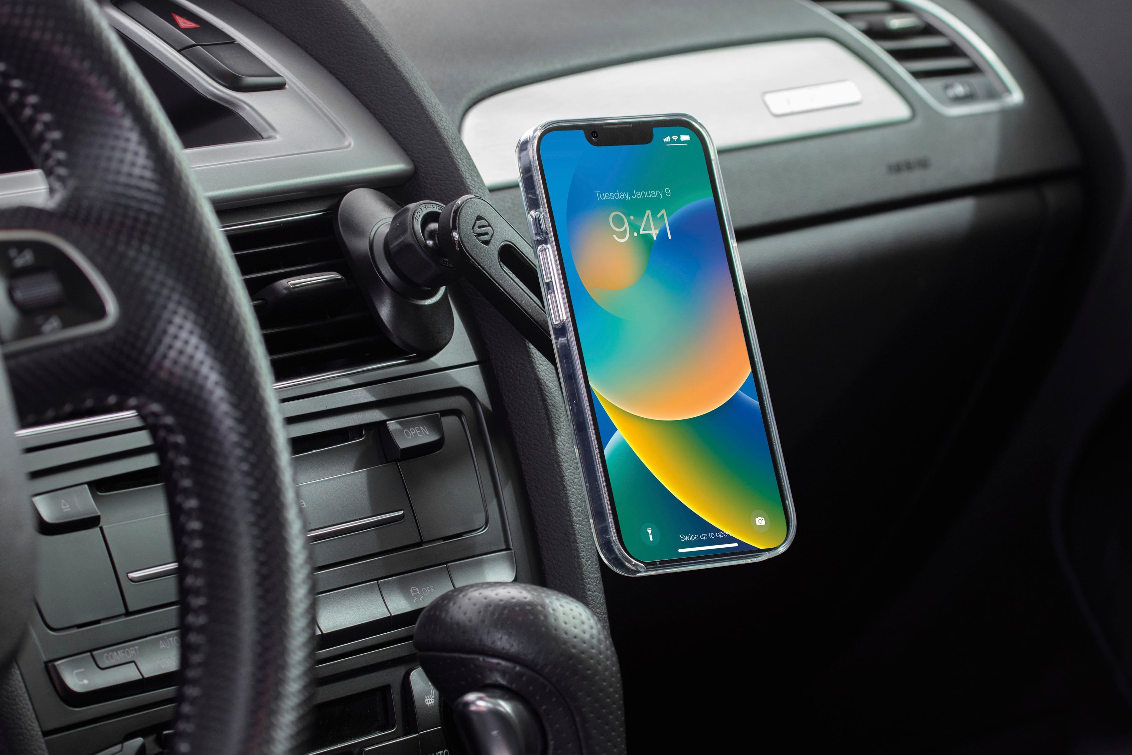 The image shows a cell phone placed on a car's dashboard, with the time displayed as 9:41. The phone is positioned in a holder, which is attached to the car's air vent. The phone is turned on and is likely being used by the car's occupants for navigation, communication, or entertainment purposes while driving.