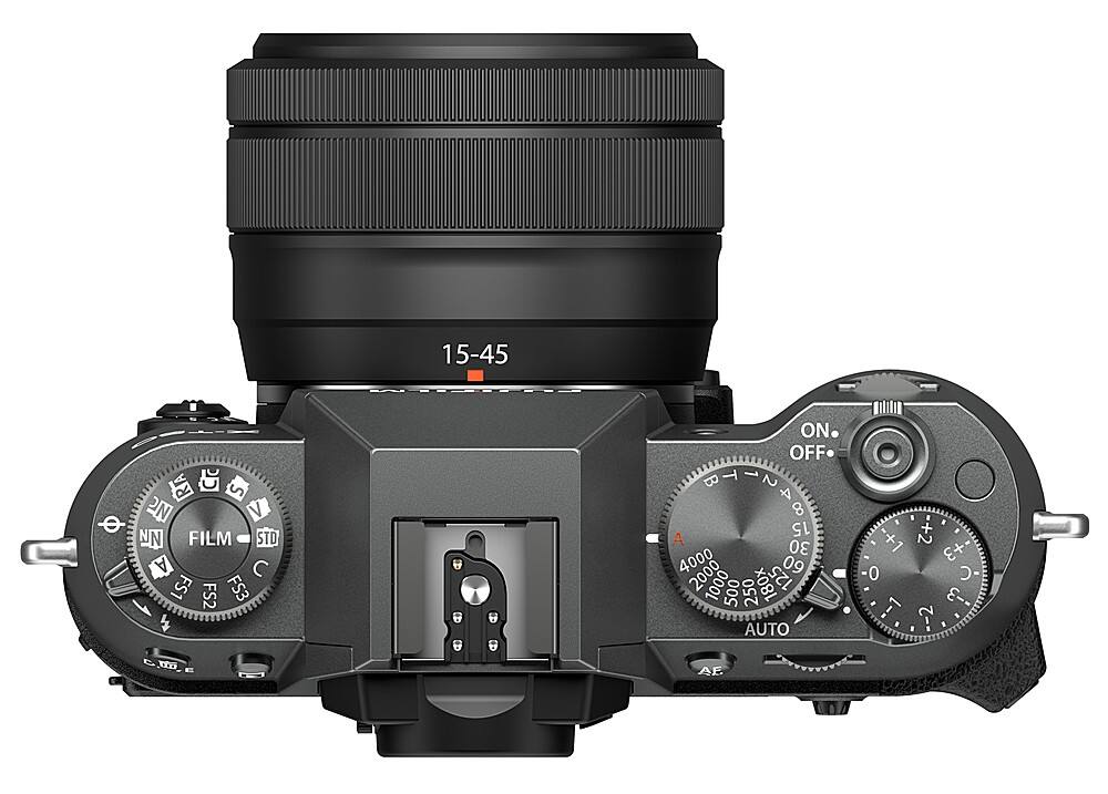 The image features a close-up of a camera lens, likely a digital camera, with a focus on the lens and the camera's controls. The camera has a 15-45mm lens, and the lens is surrounded by a black frame. The camera has a few buttons, including an ON/OFF switch, and a film speed dial. The lens is positioned in front of a white background, making it the main subject of the image.