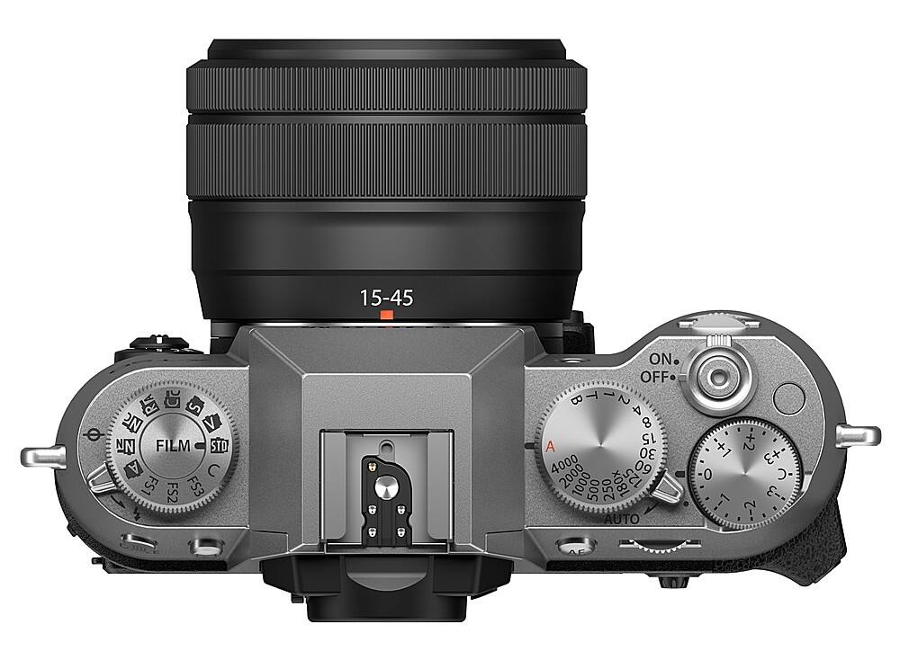 The image features a close-up of a digital camera with a lens on it. The camera has a silver body and a black lens. The camera is equipped with a viewfinder and a control panel with various buttons, including a power button, a shutter button, and a mode button. The camera also has a focus ring and a zoom ring, allowing for precise control over the focus and zoom settings. The overall appearance of the camera suggests that it is a professional-grade digital camera, designed for high-quality photography and videography.
