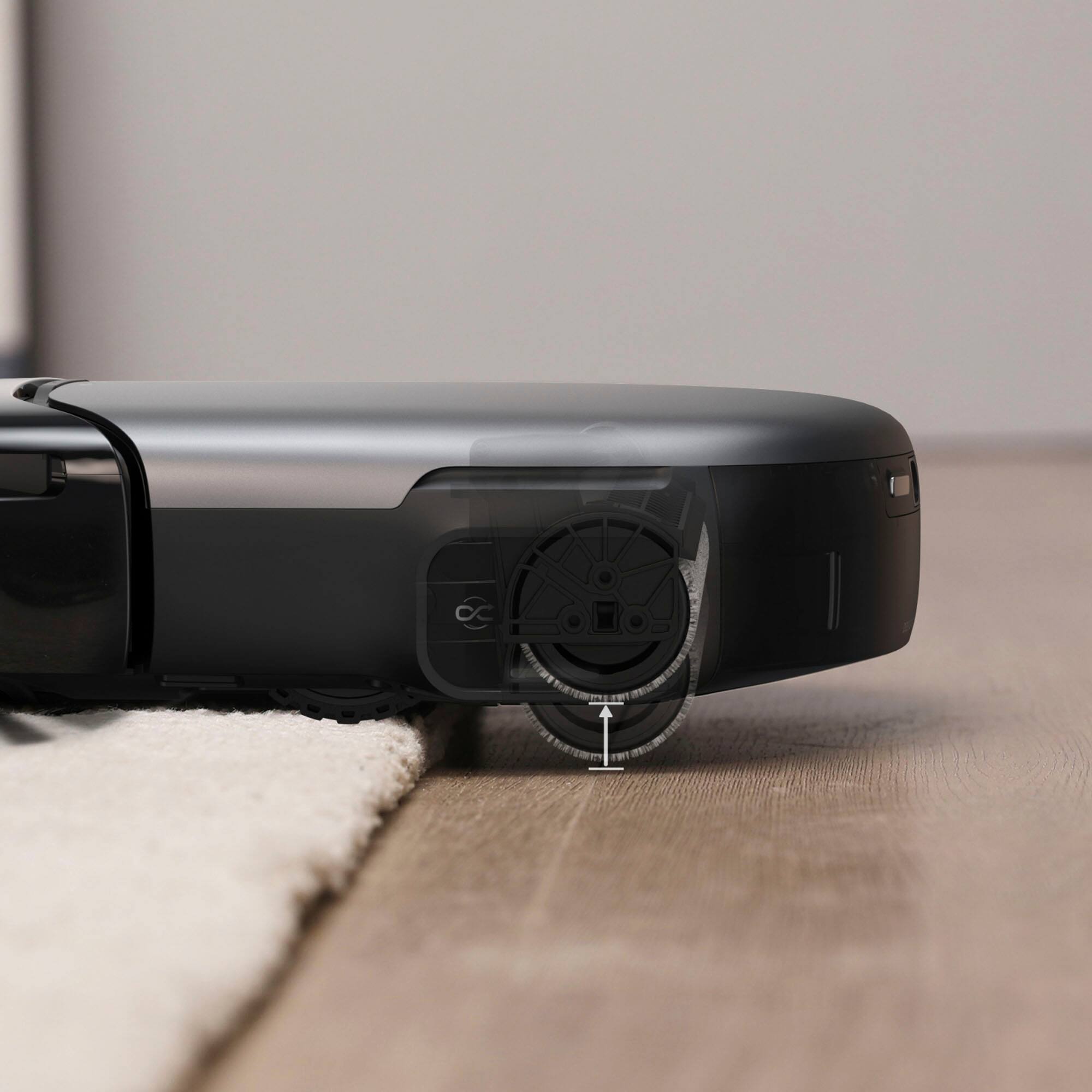 The text on the image reads "CC I  I NTEn m NETER 1 -". This is a description of a camera lens, which is placed on a wooden table. The lens is black and has a circular shape.