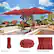 The image features a large red umbrella, which is easy to use, weather resistant, and durable in construction. The umbrella is placed in a garden setting, surrounded by potted plants and a couch. The umbrella is open and provides shade for the outdoor space.