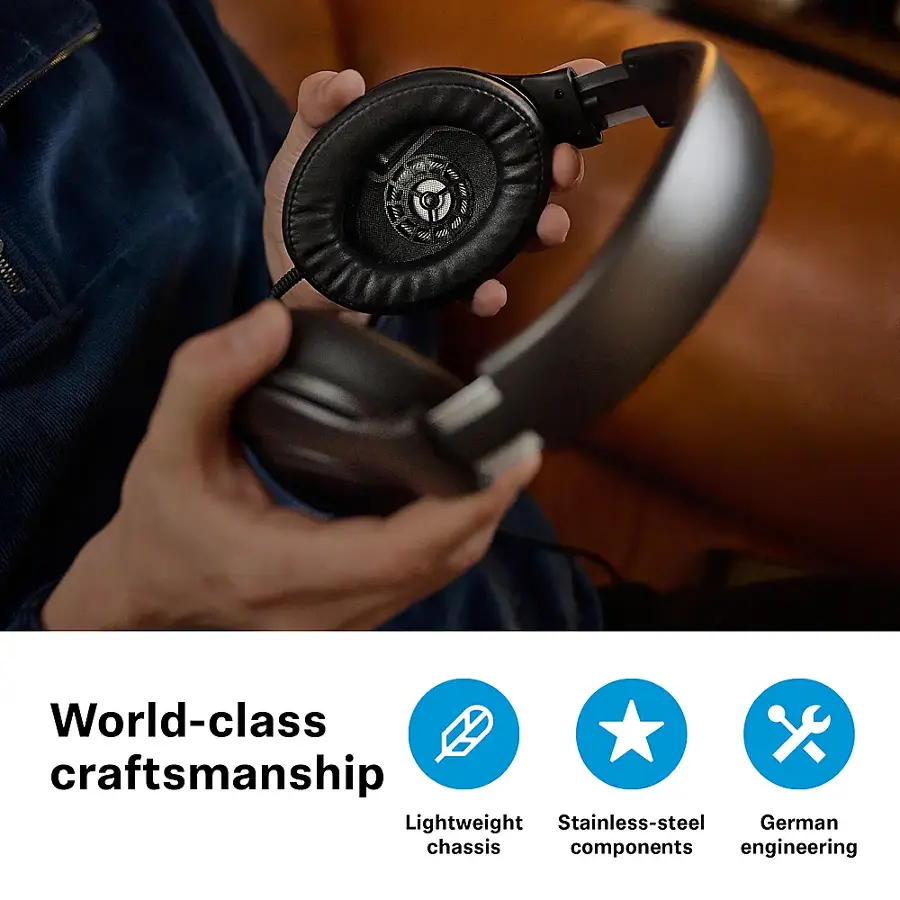 The image features a person holding a pair of headphones, showcasing the headphones' design and craftsmanship. The headphones are described as having world-class craftsmanship, lightweight stainless-steel German chassis components, and advanced engineering. The headphones are being held up to the person's ear, emphasizing their comfort and functionality.