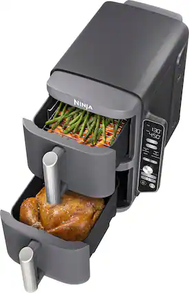 The image features a NINJA food processor with a container full of food. The food processor is filled with ingredients, including chicken and green beans. The container is placed inside the food processor, and the lid is open, revealing the food inside. The food processor is designed to cook and process various types of food, making it a versatile appliance for preparing meals.