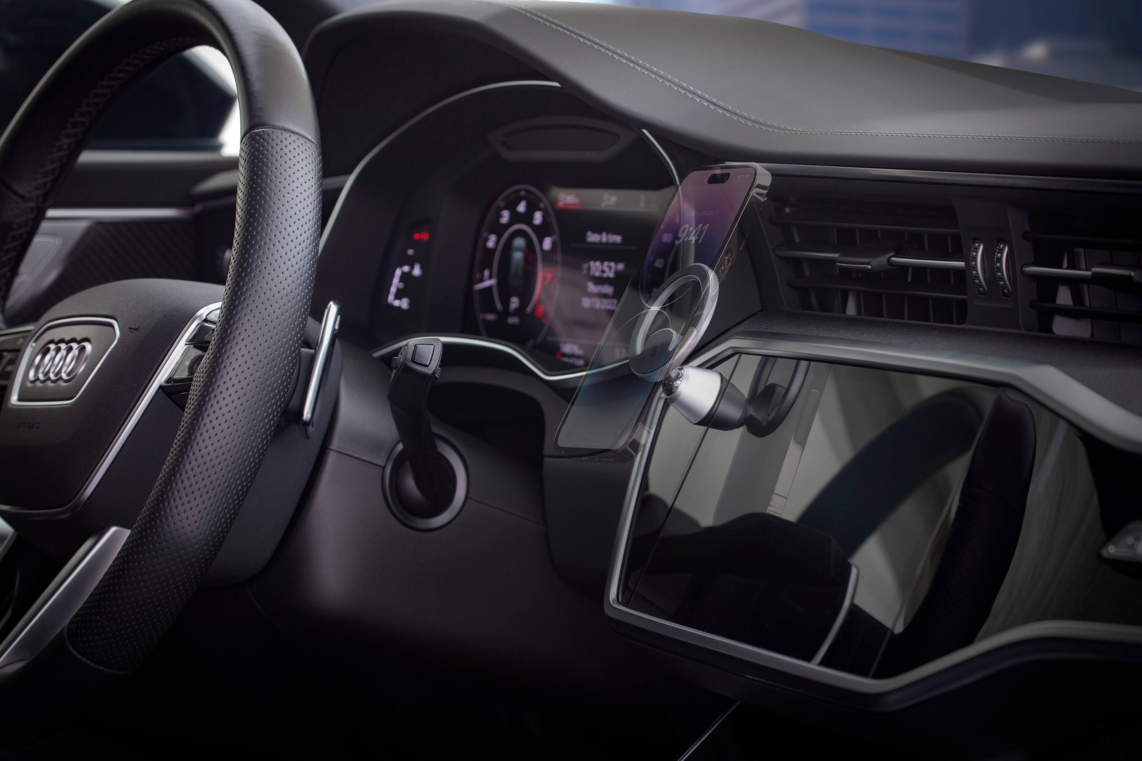 The image shows the interior of a car with a steering wheel and a dashboard. The dashboard displays the time as 10:52 and the temperature as 9:41. The car is equipped with a touch screen, which is currently displaying the time and temperature. The steering wheel is positioned in the center of the image, and the dashboard is located towards the right side of the car.