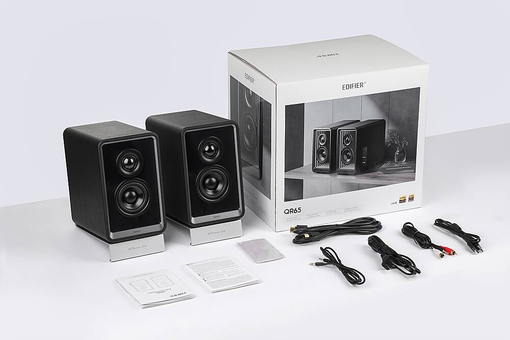 The image features a box containing a pair of Edifier speakers, which are black and silver. The speakers are placed on a white background, and they are accompanied by a set of cords and a manual. The speakers are designed to provide high-quality sound for various devices, such as computers, gaming consoles, and smartphones. The box and the speakers are placed on a white surface, which highlights the sleek design of the speakers and the box.