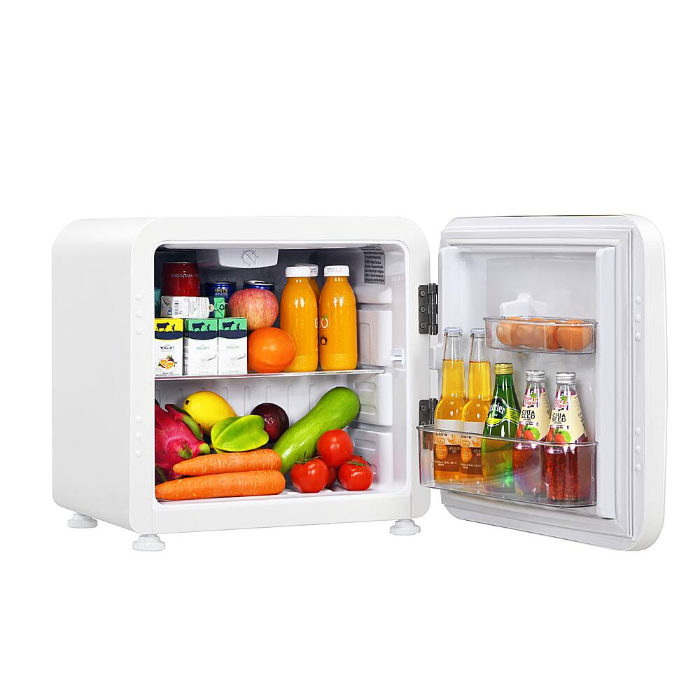 The image shows a white refrigerator with its door open, revealing a variety of food items inside. There are several bottles of drinks, including juice, and a variety of fruits and vegetables, such as apples, oranges, and carrots. The refrigerator is well-stocked, providing a diverse selection of food options for consumption.