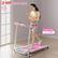 The image features a woman standing on a pink treadmill with a 2 HP quiet motor. The speed range of the treadmill is 0.5-7.5 MPH. The woman is holding a cell phone, likely using it while exercising. The scene appears to be set in a room with a window in the background.