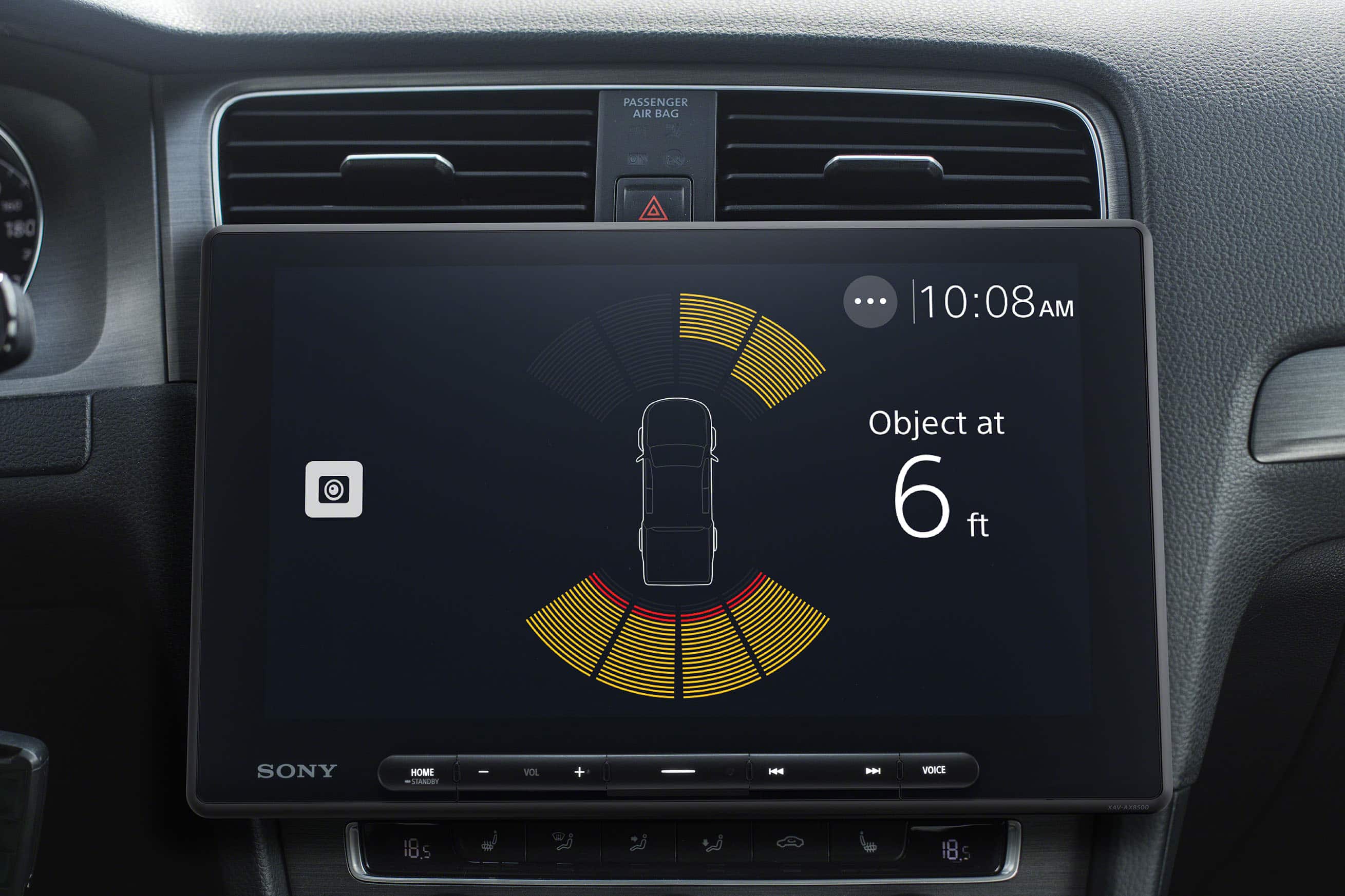 The text on the image reads "PASSENGER AIR BAG u0 180 ... | 10:08 AM Object at 6 ft SONY HOME STANDEY I VOL + H VOICE ... 20 18.5". The text has been grouped and corrected as follows:
"PASSENGER AIR BAG u0 180 ... | 10:08 AM Object at 6 ft SONY HOME STANDEY I VOL + H VOICE ... 20 18.5"
This text is likely displayed on a car's dashboard, providing information about the airbag, time, and distance to an object.