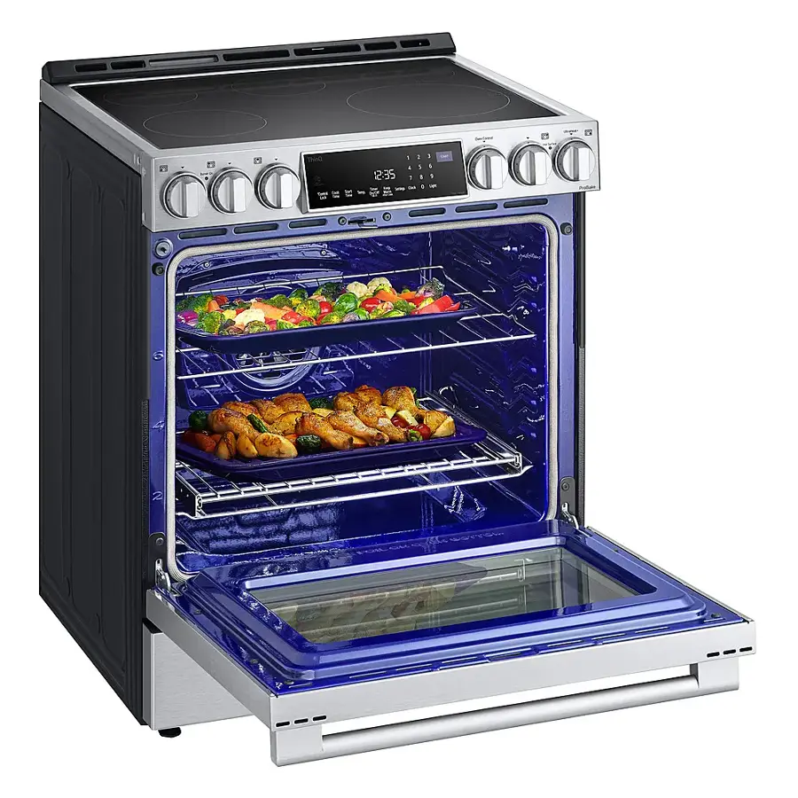 The image shows a blue oven with two trays of food inside. The oven is open, revealing the delicious meal being cooked. The trays contain a variety of food items, including broccoli and carrots. The oven is placed on a stove, and the scene is set against a white background.