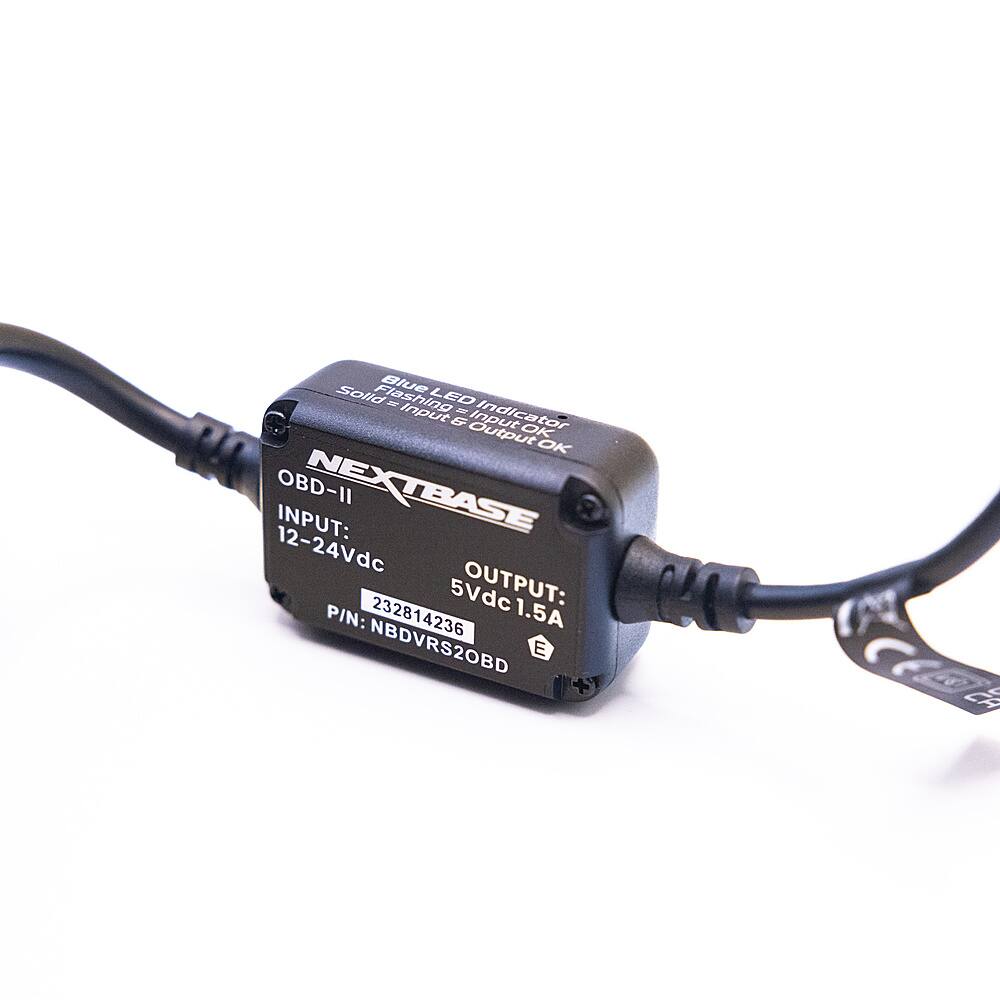 The text on the image reads: "Solid Blue L Flashing R ED Input - Indicator & Output Input OK OK OBD-II NEXTBASE INPUT: 12-24Vdc 5Vdc OUTPUT: P/N: 232814236 1.5A NBDVRS2OBD E + S." This text describes the features and specifications of a device, likely a car accessory or a piece of electronic equipment. The device has a solid blue light flashing, indicating that it is functioning properly. The input voltage range is 12-24Vdc, and the output voltage is 5Vdc. The device is compatible with OBD-II systems and has the model number NBDVRS2OBD. The device also has an input and output connector, which can be used to connect it to other electronic devices or systems.