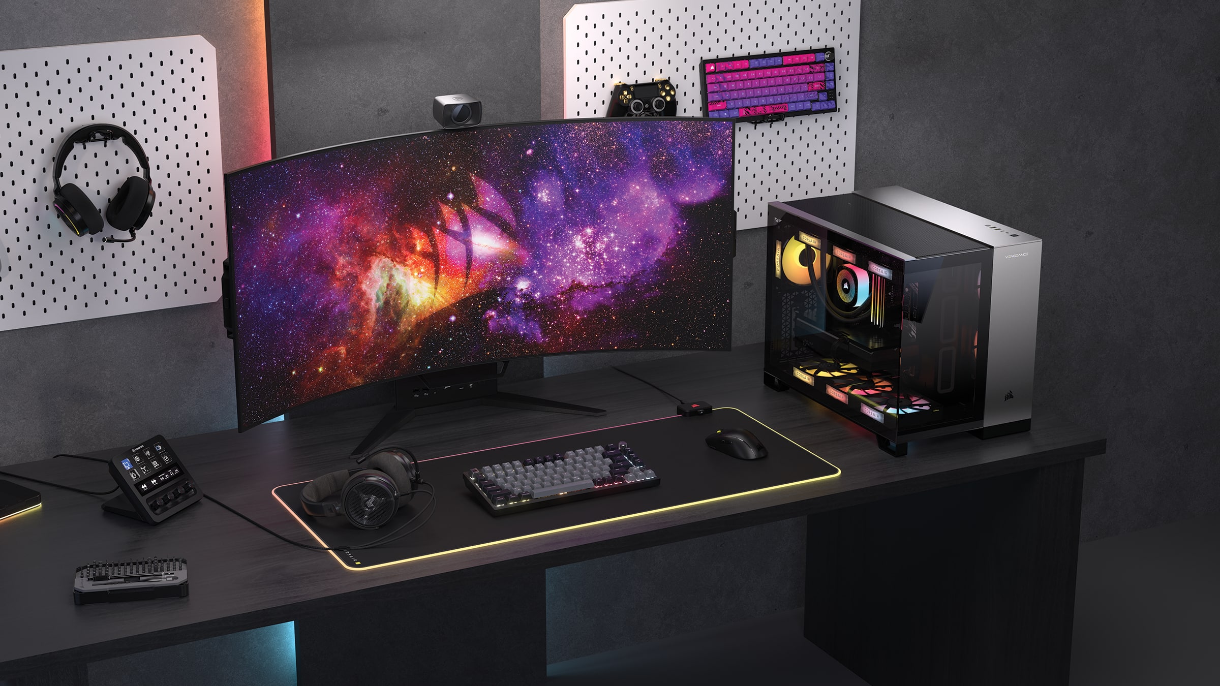 A 4K OLED computer monitor is displayed on a desk with a keyboard, mouse, and headphones.