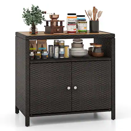 The image features a wicker cabinet with various items on top of it. There are several bottles, a bowl, a spoon, a vase, and a potted plant. The bottles are arranged in a row, with some of them placed closer to the front and others further back. The bowl is positioned towards the right side of the cabinet, while the spoon is located on the left side. The vase is placed in the middle of the cabinet, and the potted plant is situated on the left side, towards the back. The arrangement of these items creates a visually appealing and organized display.