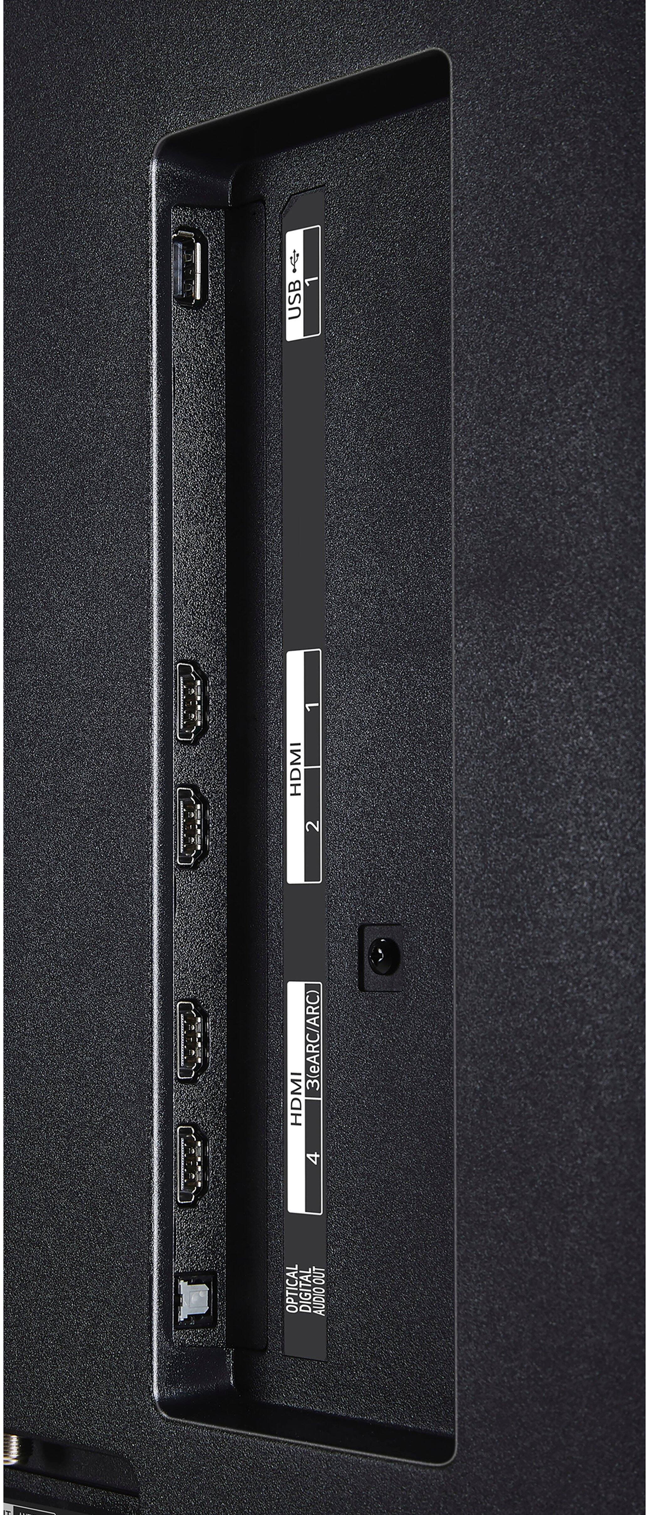 The image shows a black electronic device with a row of ports, including a USB port, an HDMI port, and an optical digital audio out port. The device also has a 2.1 channel audio system, which includes two speakers and a subwoofer. The back of the device features a number of ports, including a USB port, an HDMI port, and an optical digital audio out port. The device is designed to provide a high-quality audio and video experience for users.