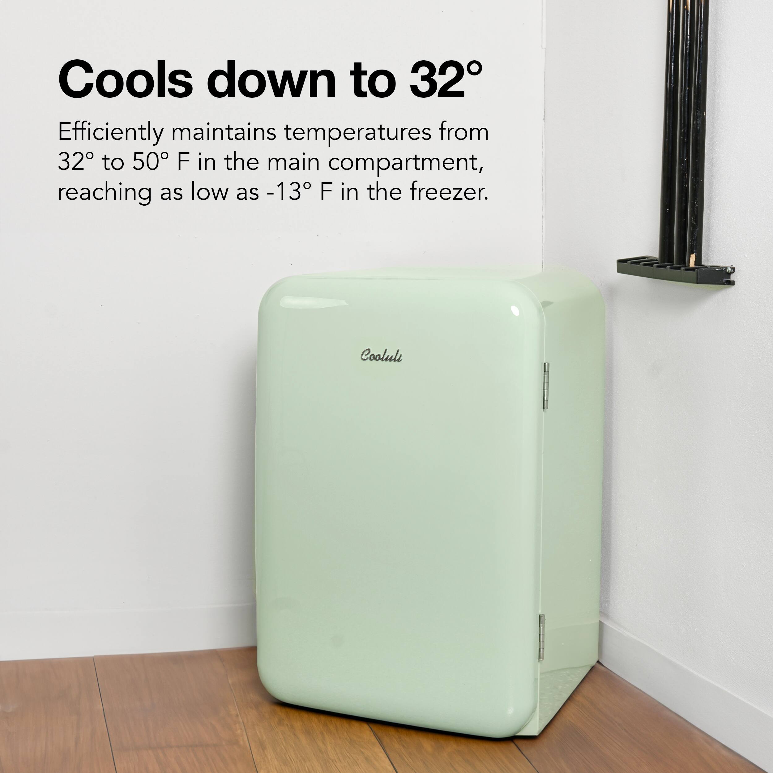 The image features a white refrigerator with the text "Cools down to 32 Efficiently maintains temperatures from 32 to 50 F in the main compartment, reaching as low as 13 F in the freezer." The refrigerator is placed on a wooden floor, and it is positioned next to a wall. This appliance is designed to maintain a consistent temperature within its compartments, ensuring that food items are stored at the appropriate temperatures for preservation and safety.