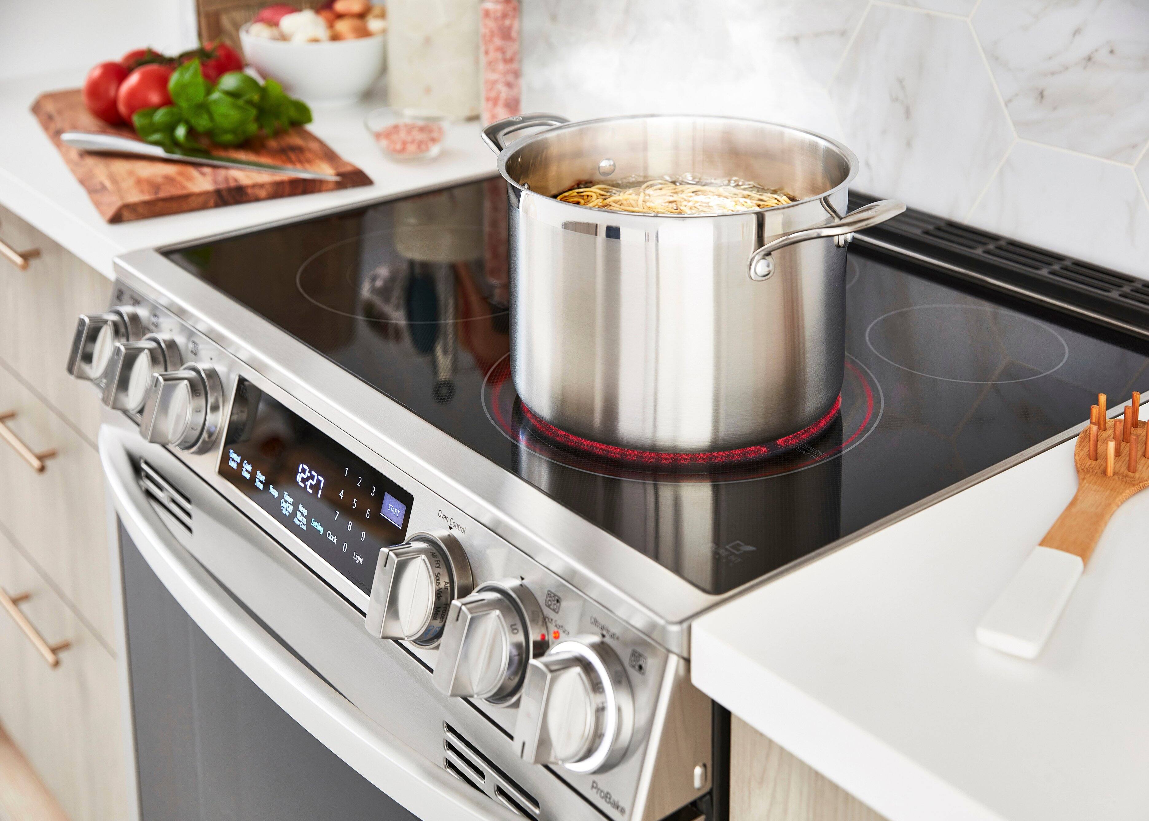 The image shows a kitchen with a stove top oven. The stove has a pot on it, and there is a timer set to 123 minutes. The oven has a digital display, which shows the time and temperature settings. The stove is surrounded by various kitchen items, including a bowl, a knife, and a spoon. There is also a cutting board nearby, and a bottle can be seen in the background.