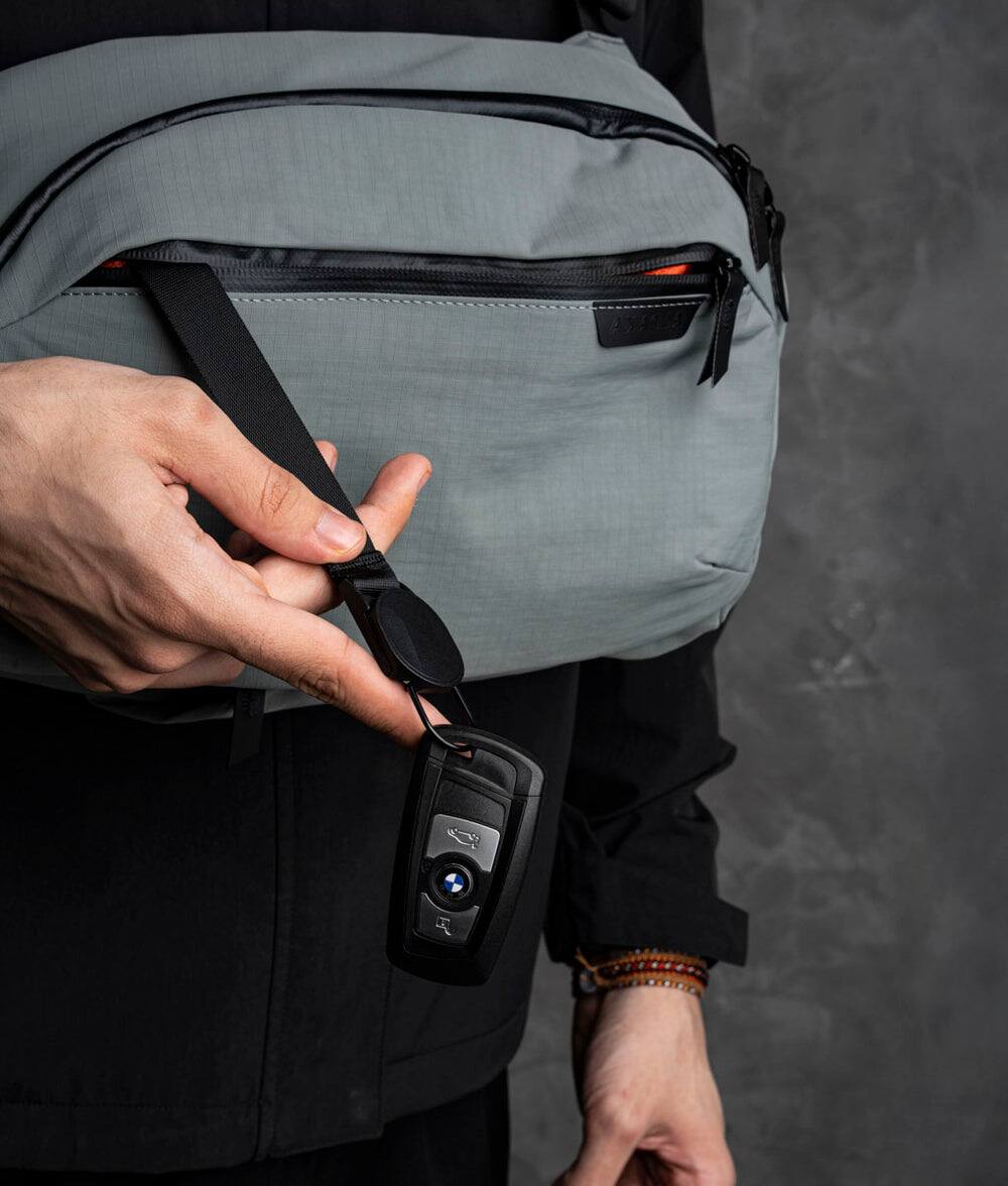 Alt View 2. ALPAKA - Crossbody Sling Bag 7.5L (Left Shoulder) for Men, Fits 11" Tablet, Phone Sleeve, Bottle Pocket, Luggage Pass-Through - Grey Axoflux 210D.