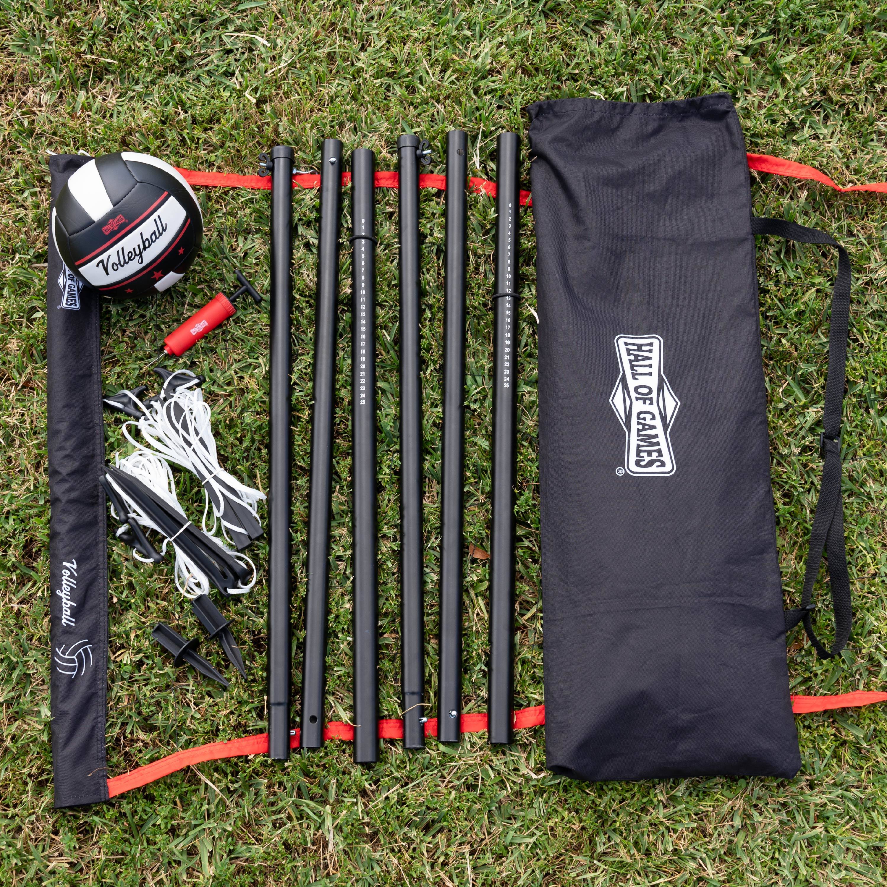 The image shows a set of volleyball equipment, including a net, a bag, and a ball. The net is set up on the grass, and the bag is placed nearby. The ball is also present on the grass, close to the net. The Hall of Games logo is visible on the bag, indicating that it is a product from the Hall of Games brand.