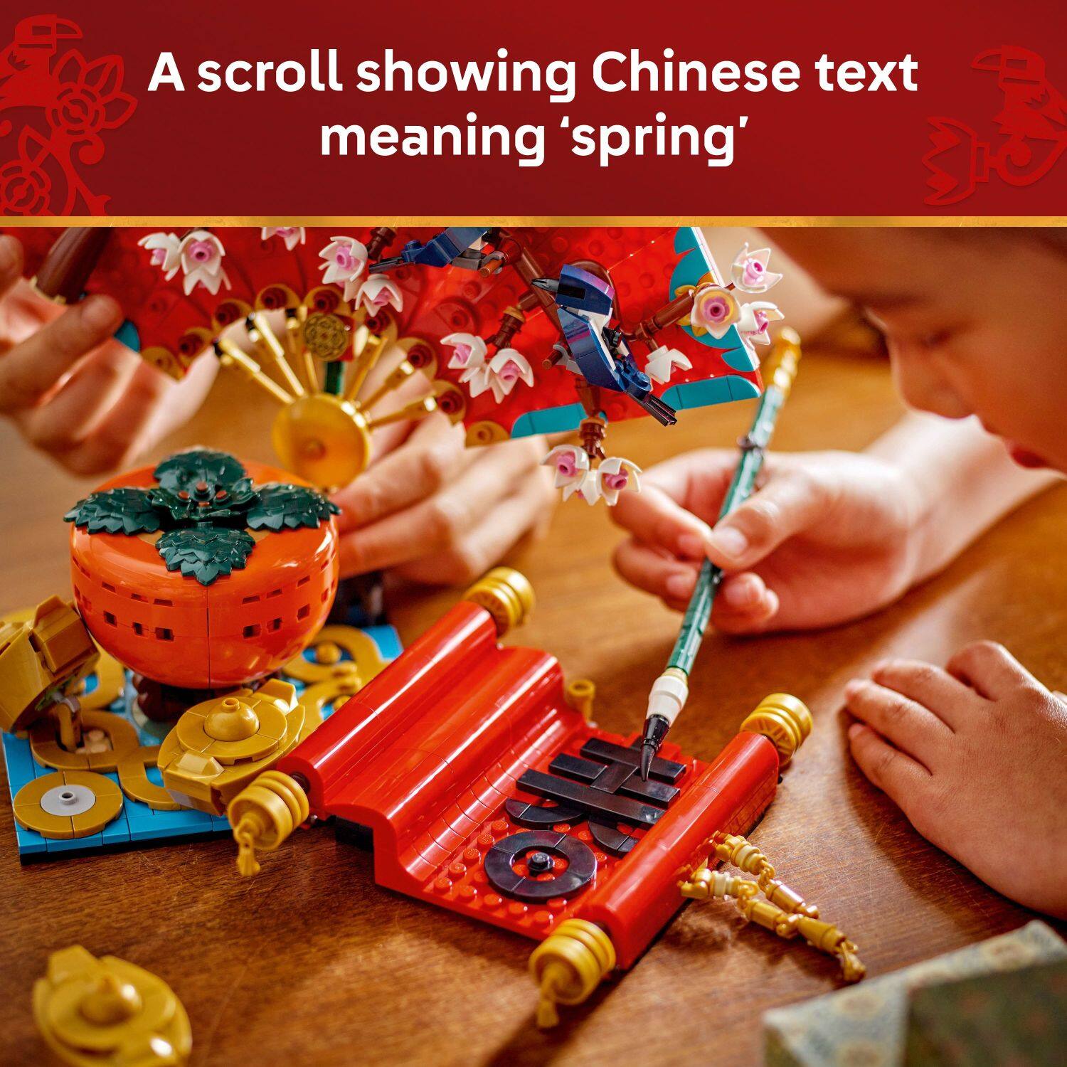 A scroll showing Chinese text meaning 'spring' is displayed on a table.