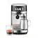 The image features a Breville coffee maker with a silver carafe and a glass of coffee. The coffee maker is placed on a counter, and there is a cup of coffee next to it. The coffee maker is designed to make coffee quickly and efficiently, making it a popular choice for busy households.