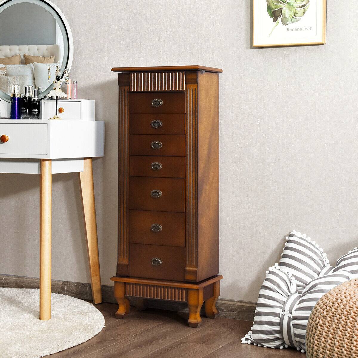 The image features a wooden dresser with a mirror on top of it. The dresser has a drawer and is placed next to a wall. There is also a picture hanging on the wall above the dresser. Additionally, there is a pillow on the floor near the dresser.