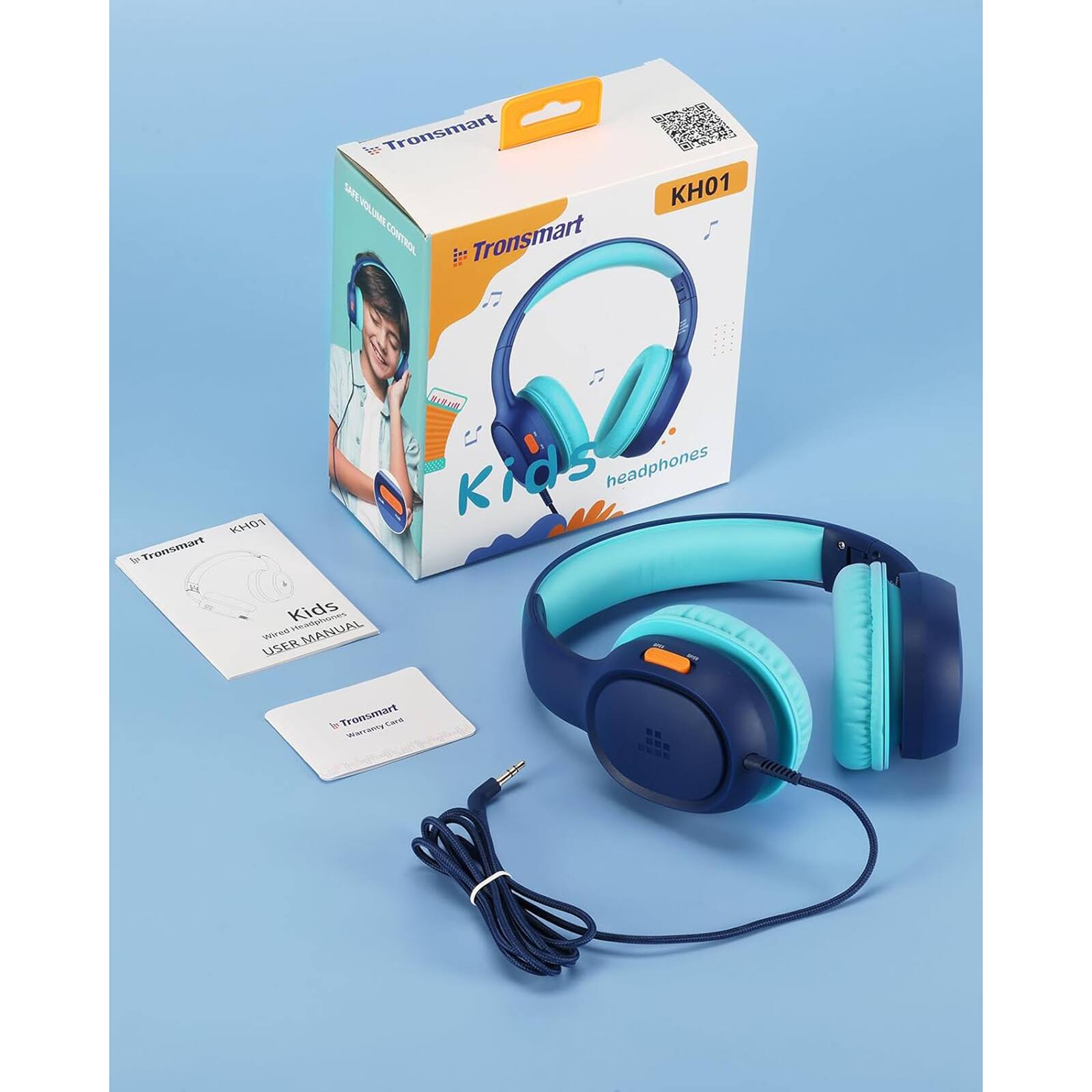 Tronsmart KH01 Kids Headphones are designed for children and come with a manual and a USB cable. The headphones are blue and have a volume control button.