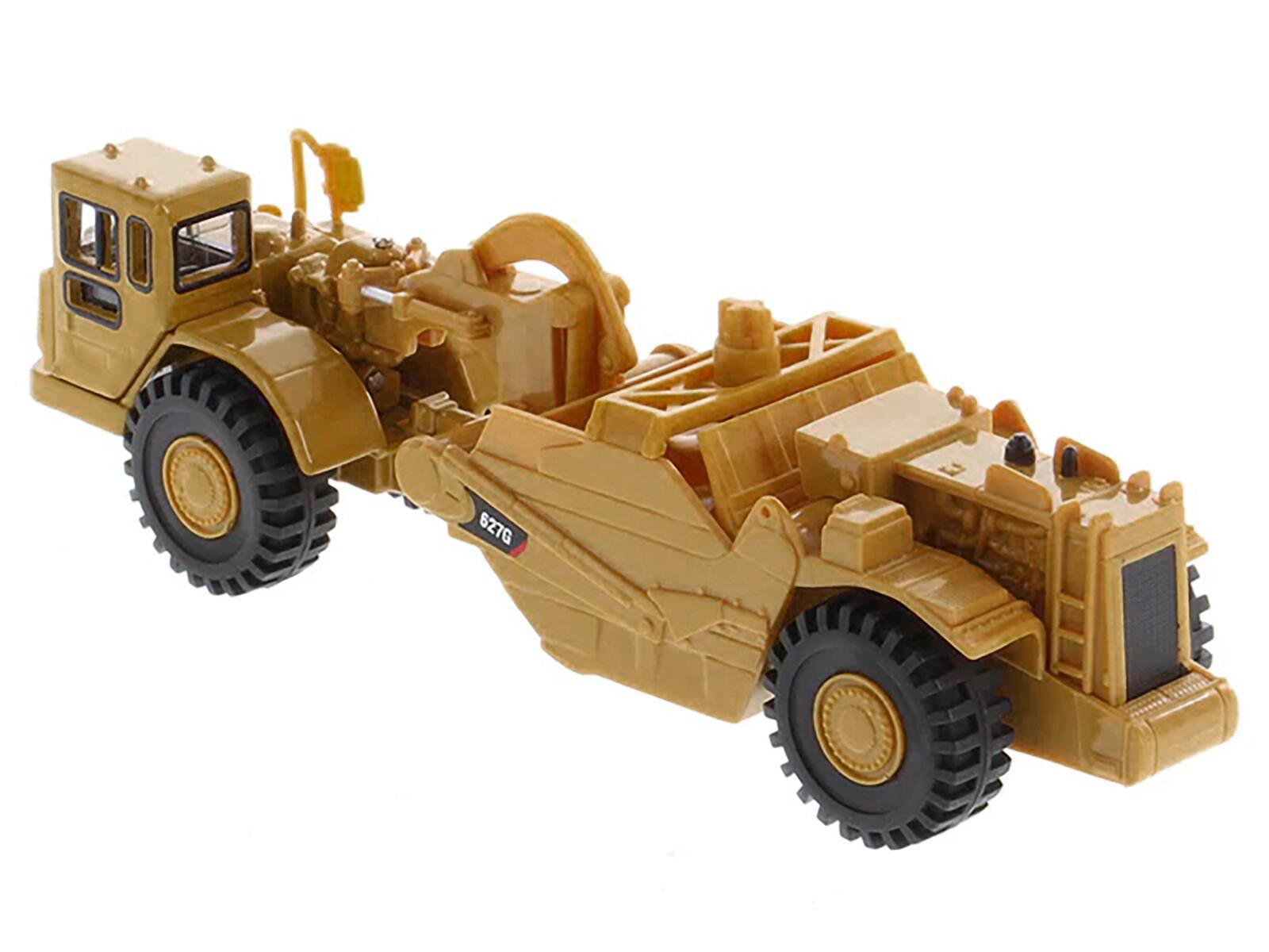 Left. Diecast Masters - CAT Caterpillar 627G Auger Scraper Yellow 1/87 (HO) Diecast Model by Diecast Masters - Yellow .