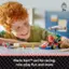 The image features a young boy with red hair, sitting at a table with a variety of toys, including a red and blue toy car. The boy is smiling and appears to be enjoying himself. The toys are set up for racing, role-play fun and more, making it an ideal playtime for the child.