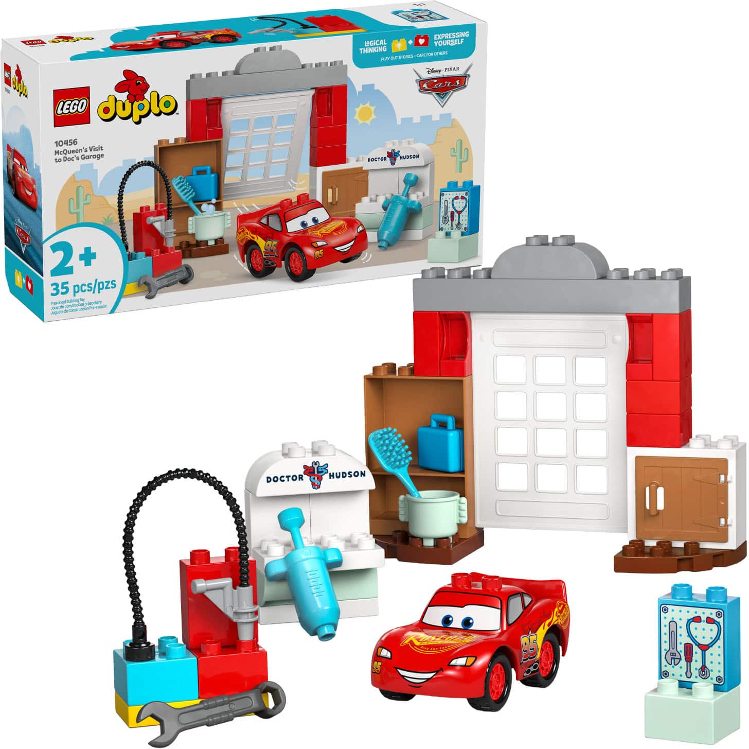 A LEGO Duplo 10456 McQueen's Visit to Doc's Garage, featuring a red car with a smiling face, a garage with a hose, and various tools. The set includes 35 pieces and is suitable for ages 2+.