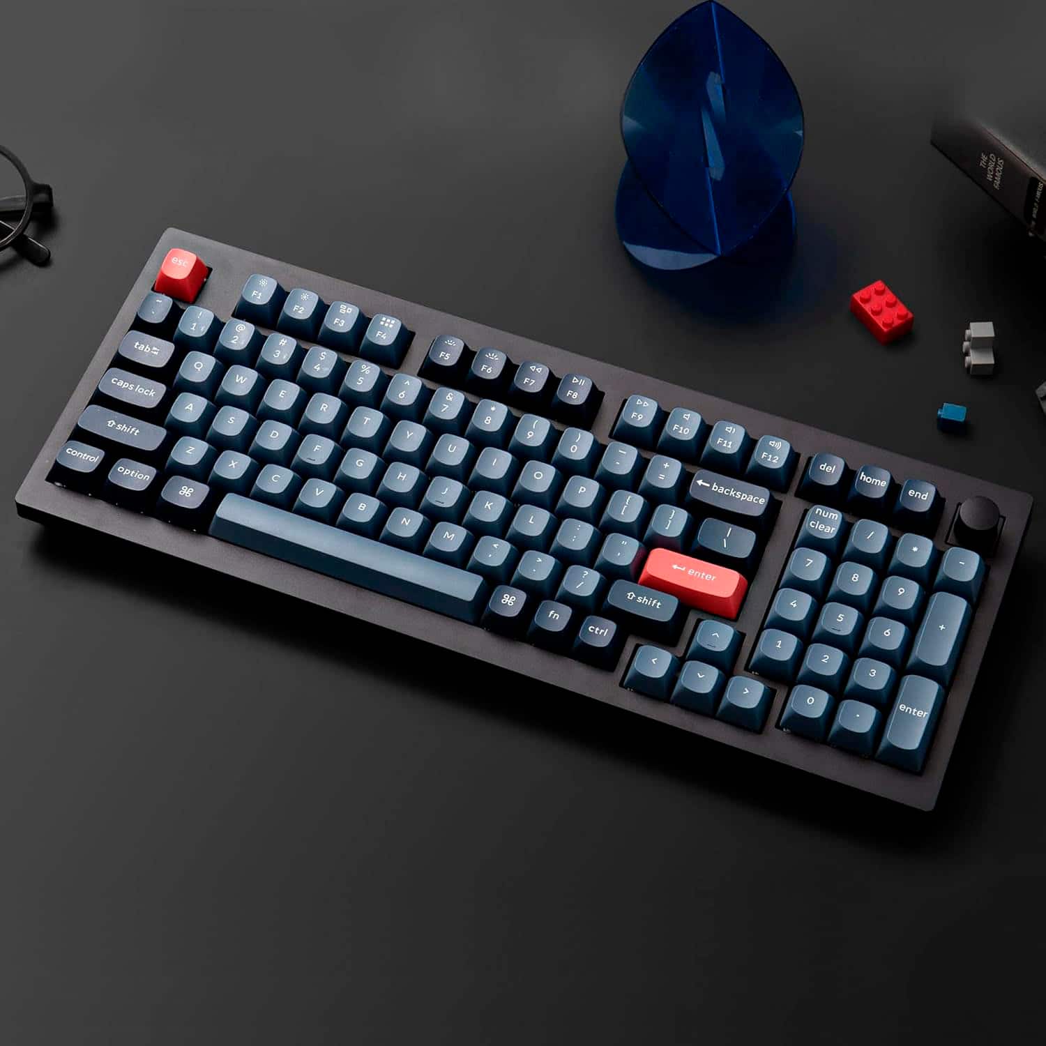 The text on the image is a list of keys on a keyboard. The keys include letters, numbers, and symbols such as F1, F2, F3, F4, F5, F6, F7, F8, F9, F10, F11, F12, and the arrow keys. There is also a red button in the middle of the keyboard.