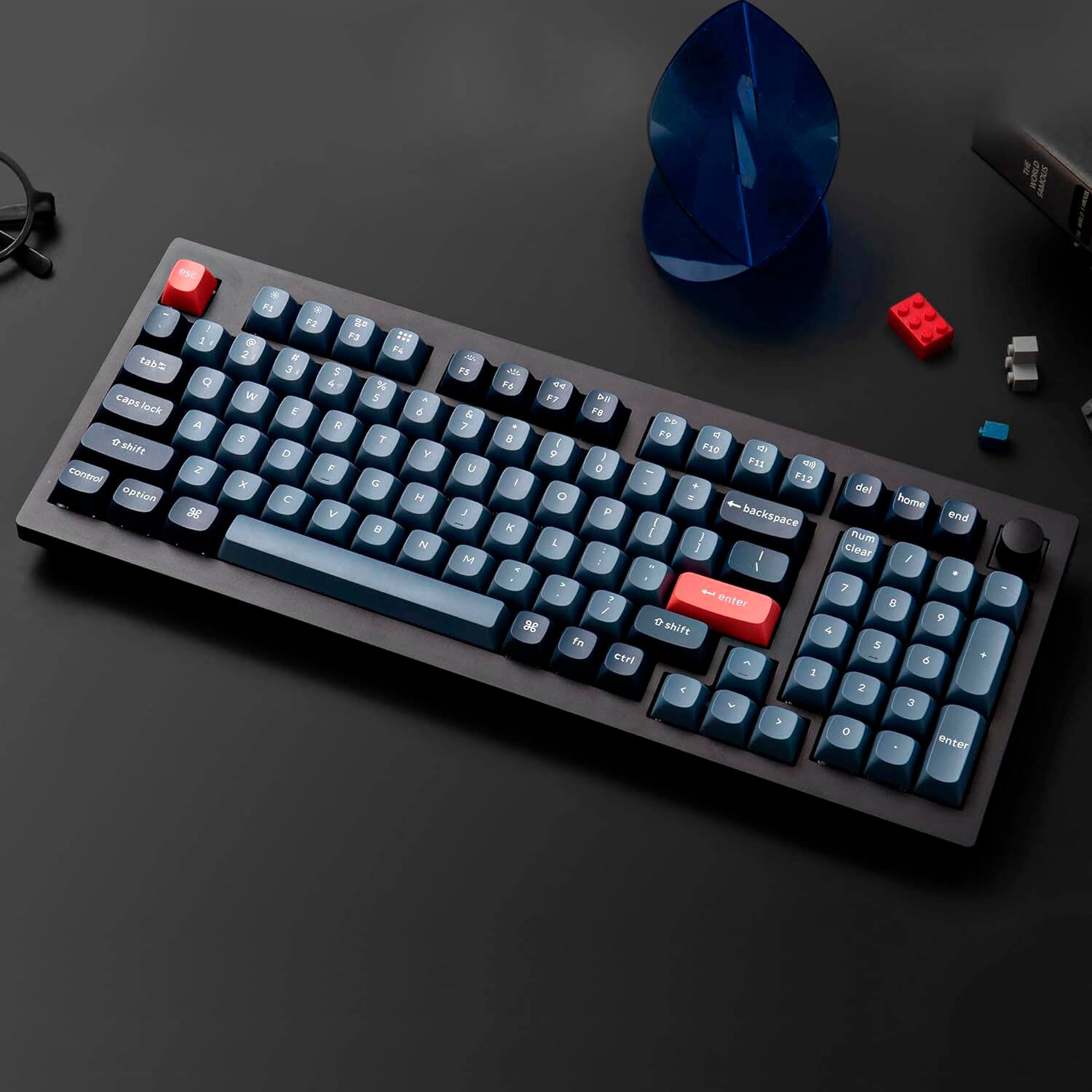 The text on the image is a list of keys on a keyboard. The keys include letters, numbers, and symbols such as F1, F2, F3, F4, F5, F6, F7, F8, F9, F10, F11, F12, and the arrow keys. There is also a red button in the middle of the keyboard.